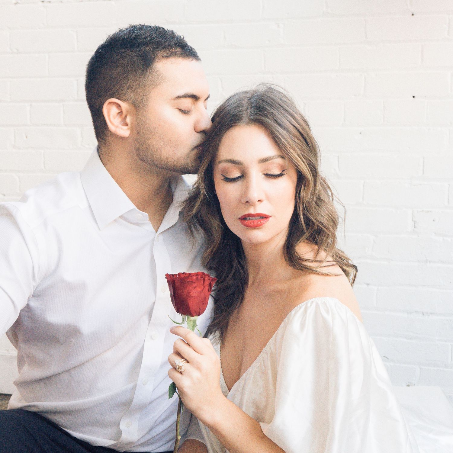 Romantic couples portrait featuring a couple sharing a quiet moment with a red rose during an engagement session by Sweetly Kept Photography