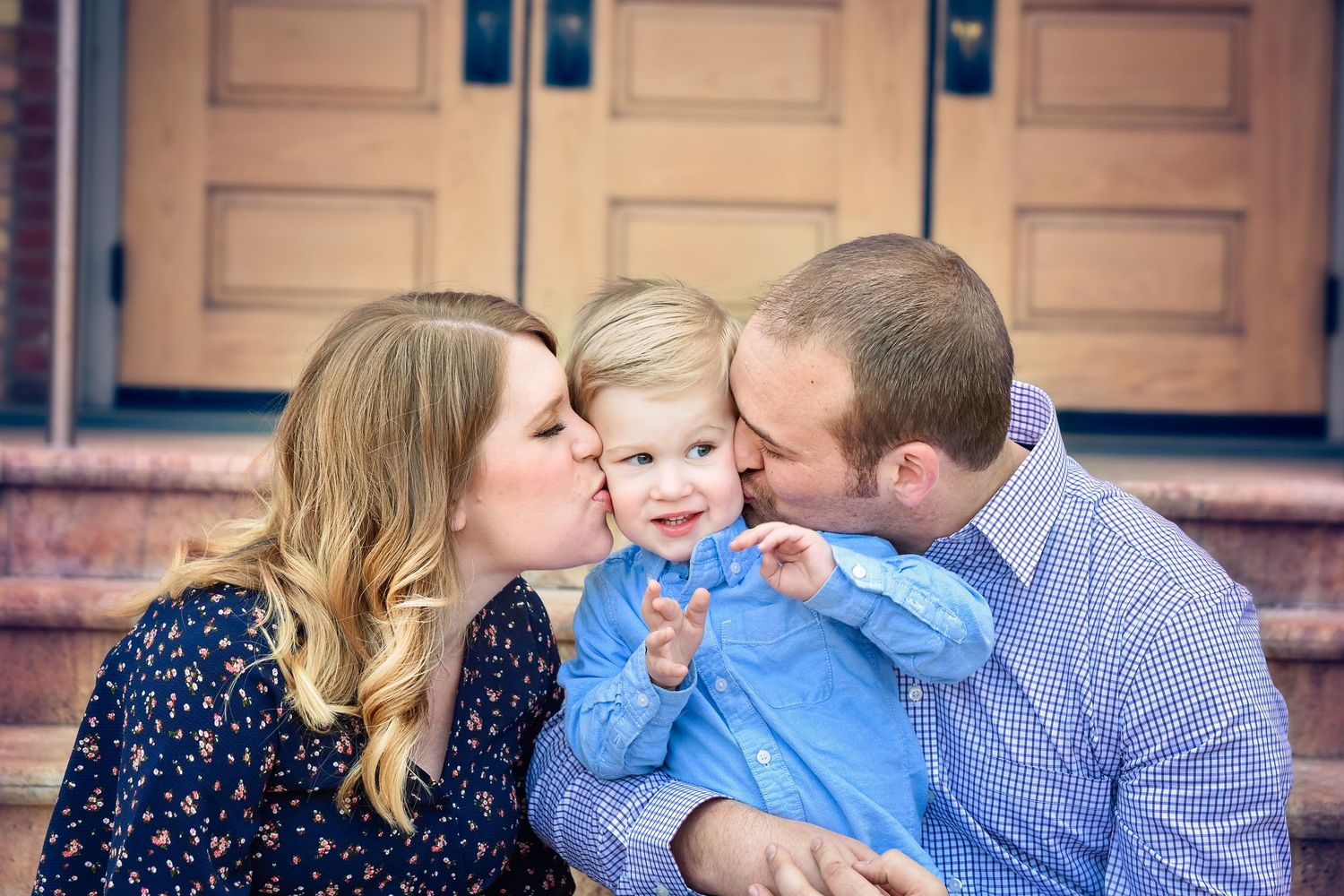 mother and father kissing son