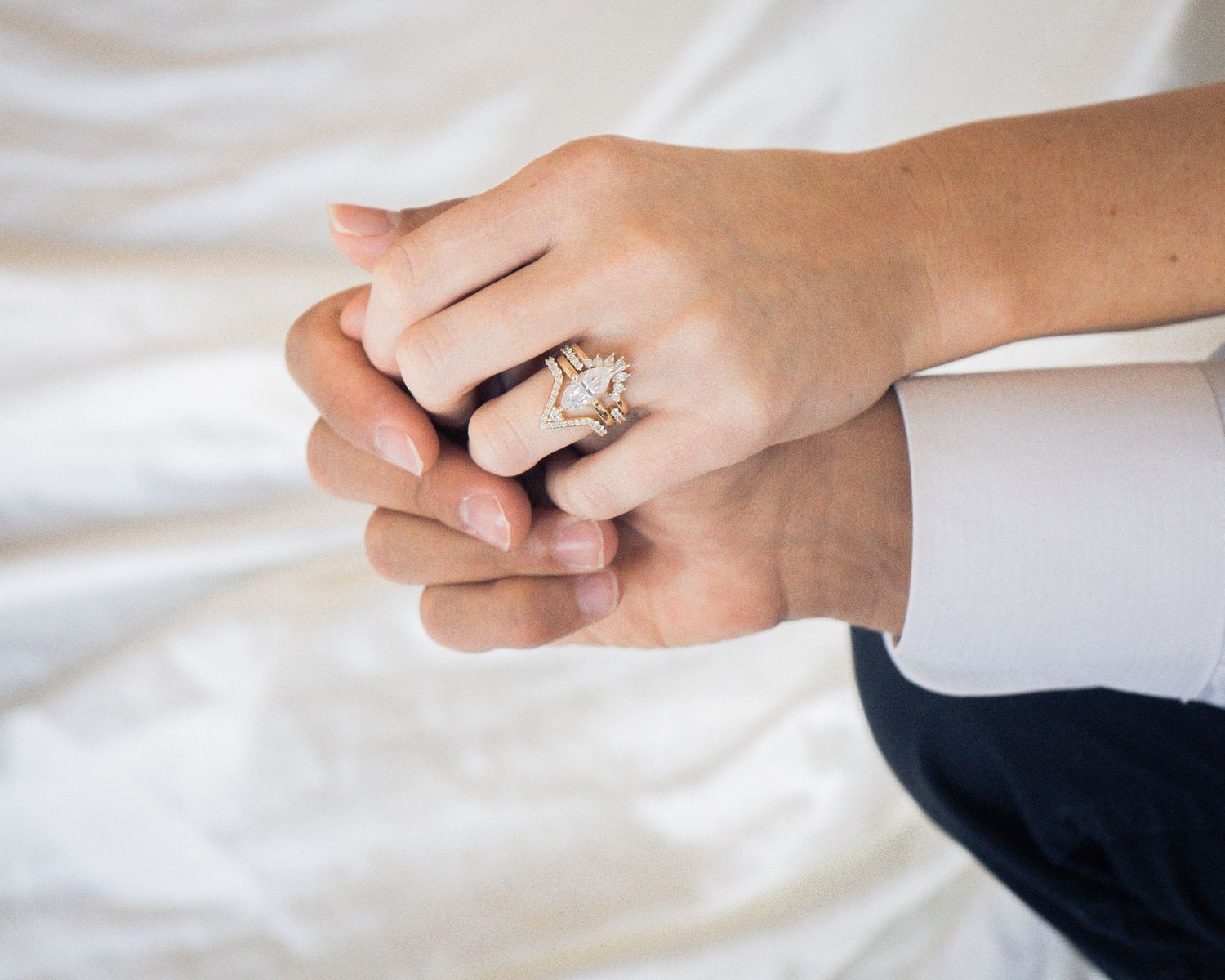 Close-up of hands holding with an engagement ring, symbolizing love and commitment in an engagement session by Sweetly Kept Photography