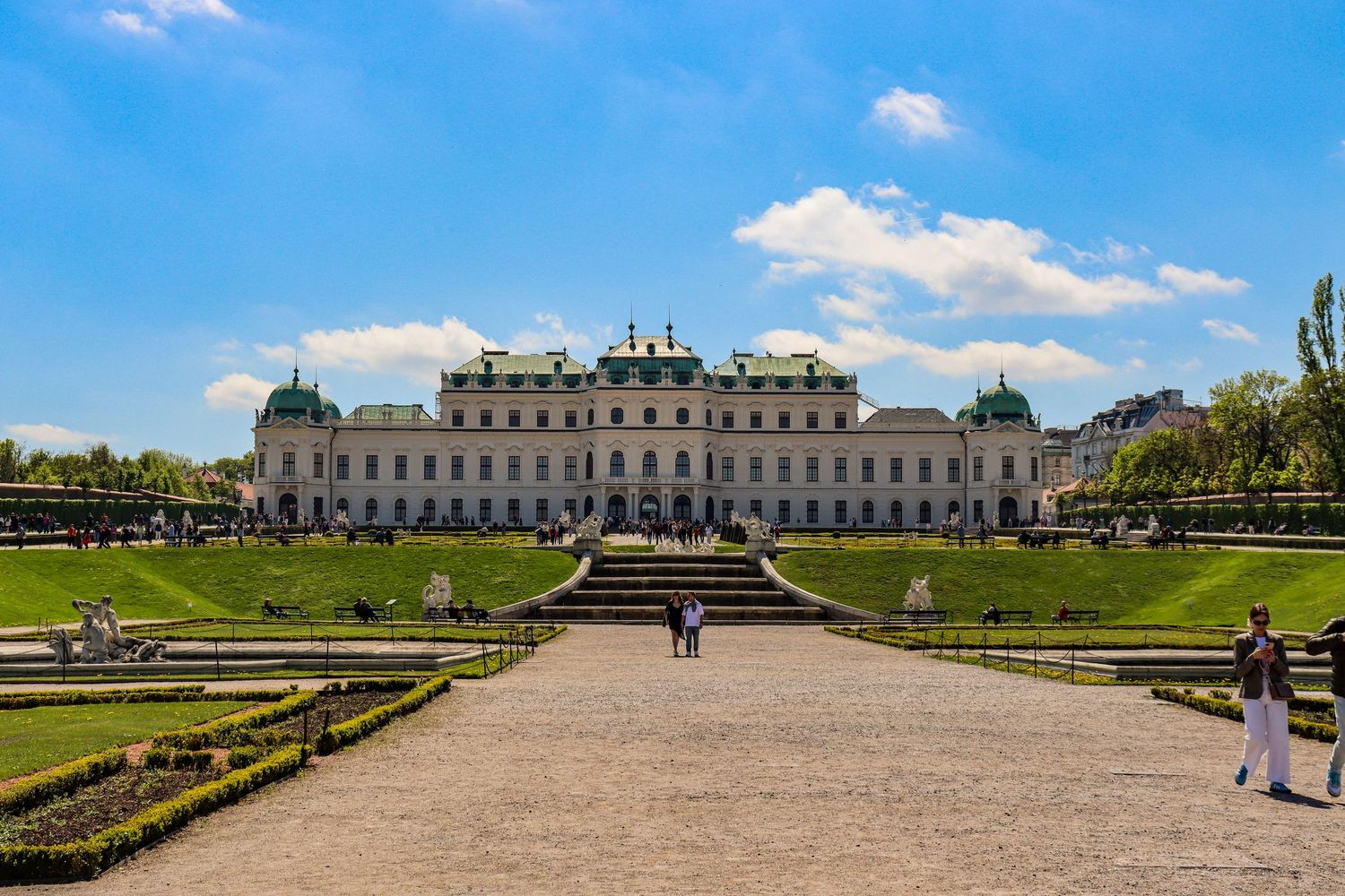 Belvedere Palace Vienna with formal gardens under bright blue sky.