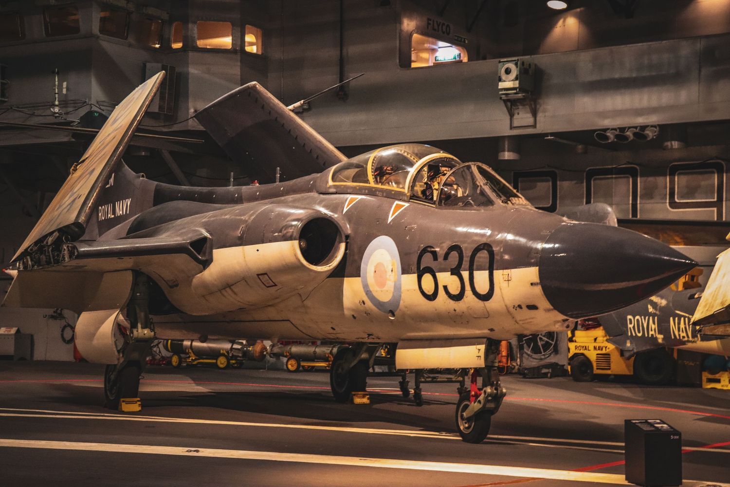 Vintage Royal Navy jet aircraft number 630 displayed in museum hangar.