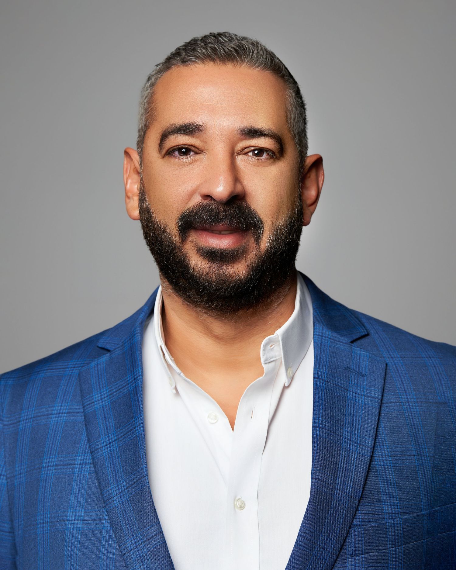 Professional headshot series of businessman in blue checkered suit and white shirt.