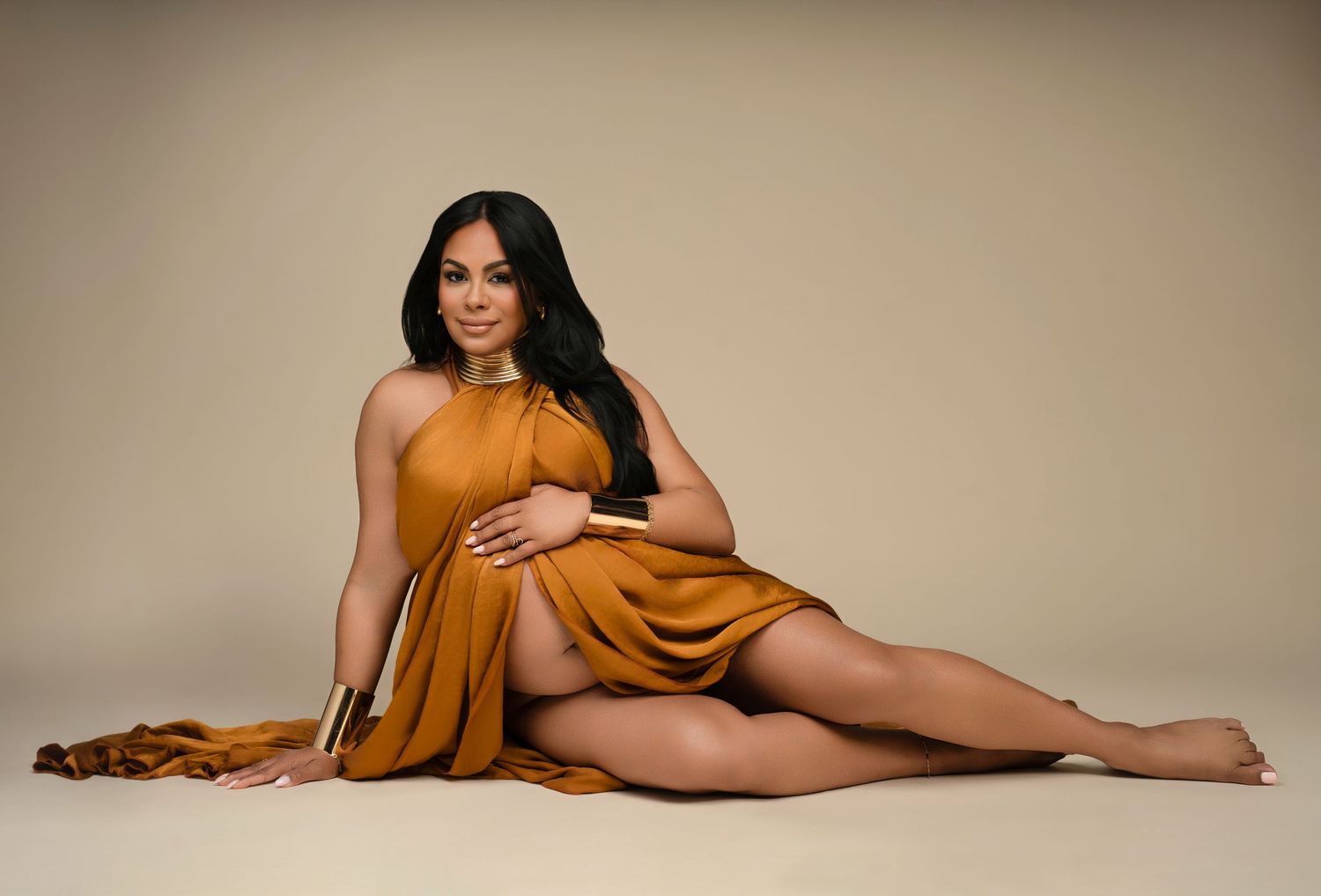 Artistic boudoir photos with person posing in golden fabric against neutral background.