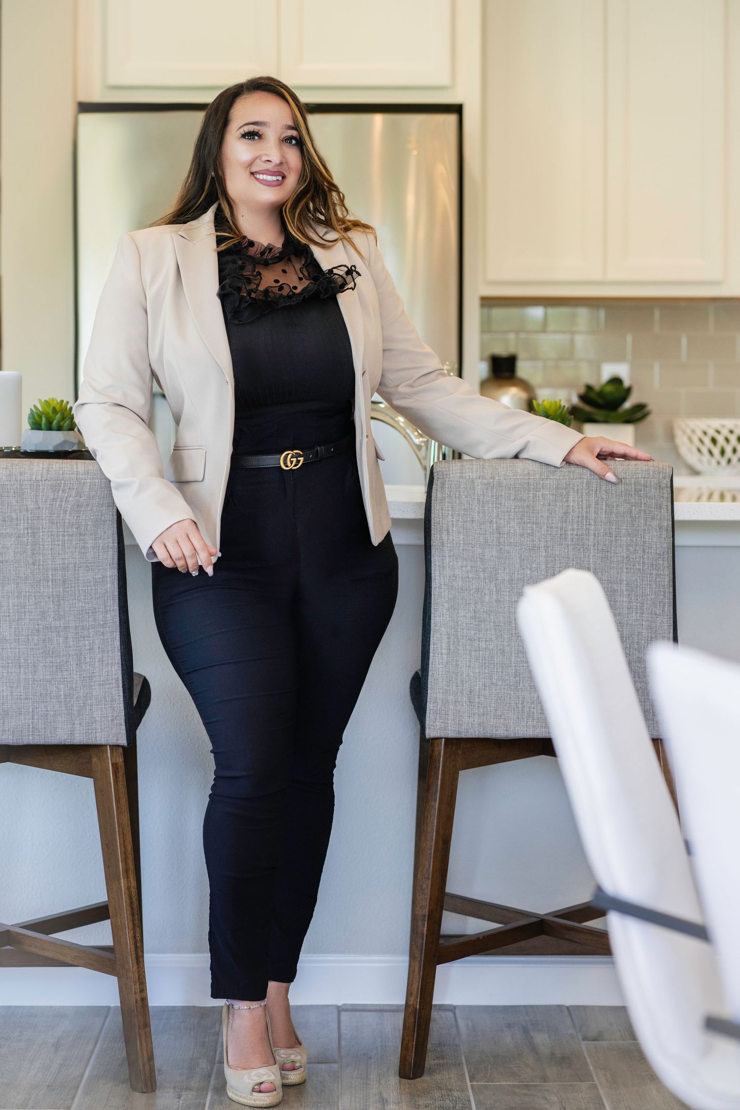 Modern business portrait in kitchen setting with gray bar stools.