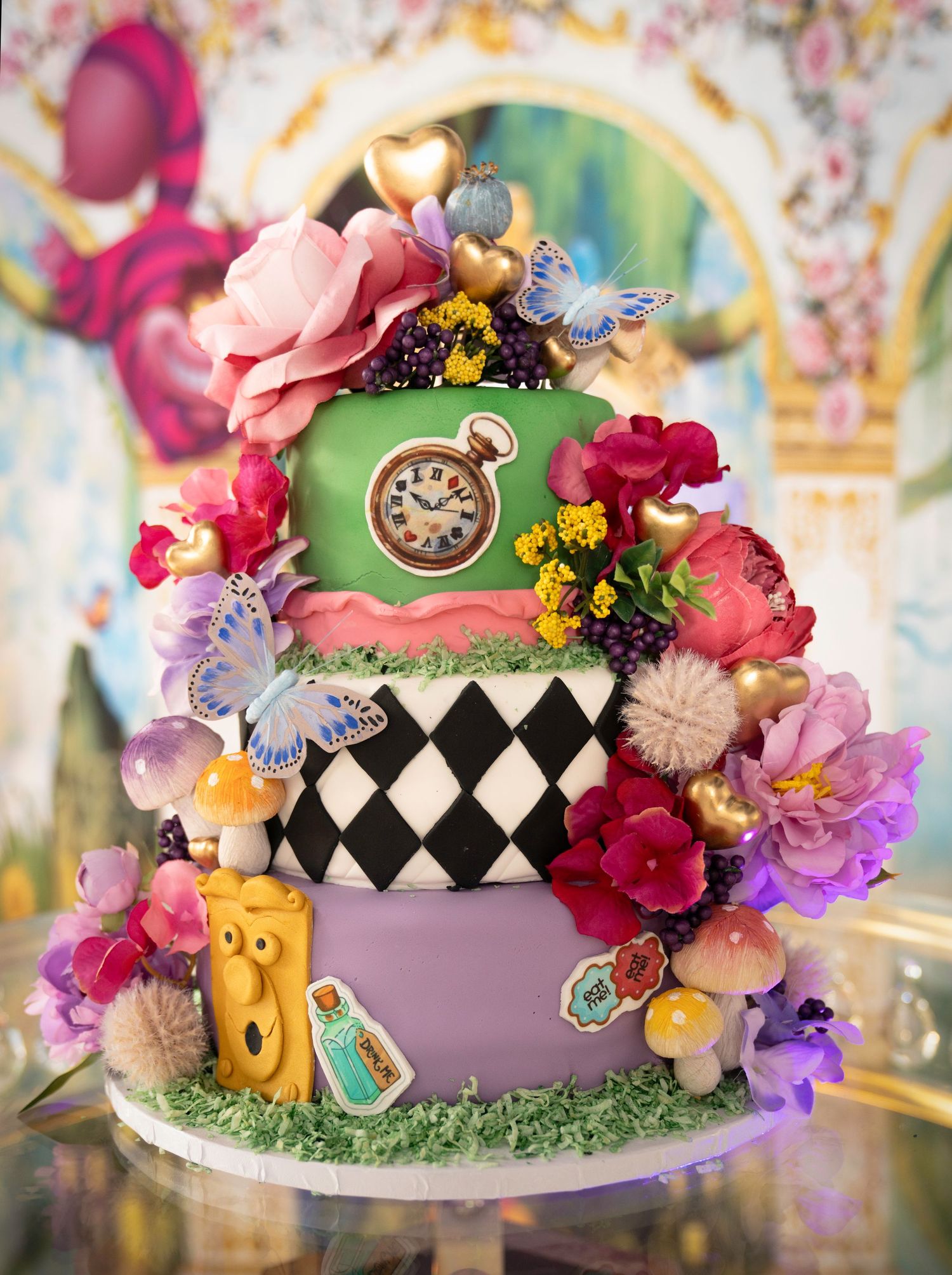 Whimsical Alice in Wonderland themed cake with colorful flowers and checkered pattern.