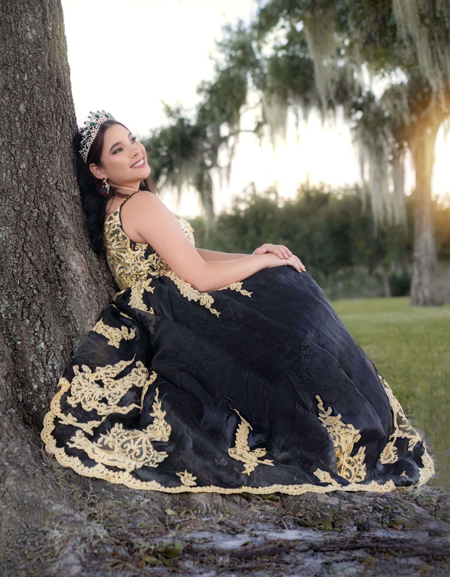 Elegant black and gold formal gown photographed outdoors at sunset.