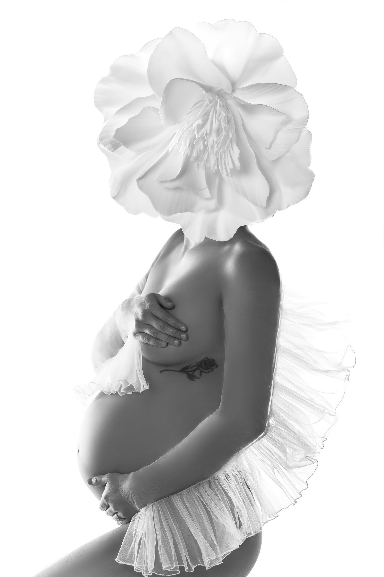 Series of artistic black and white maternity photos showing a pregnant figure in white ruffled fabric.