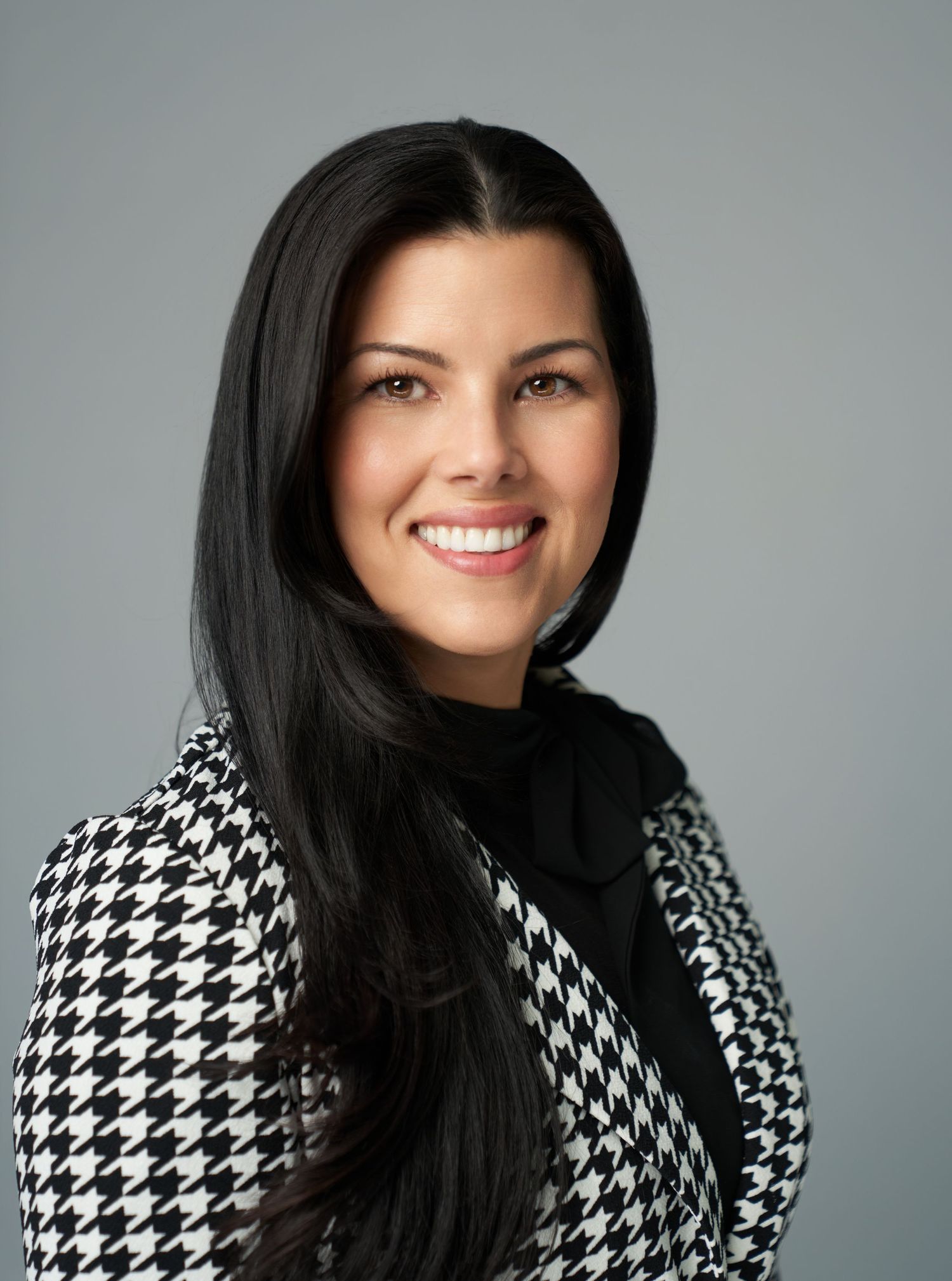 Professional portrait series showing a woman with long dark hair wearing a black and white houndstooth blazer.
