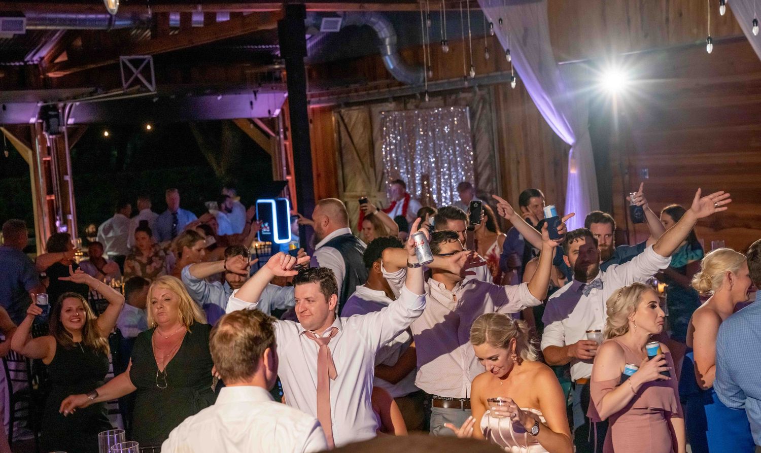 People dancing and socializing at a nightclub with colorful lighting and a festive atmosphere.