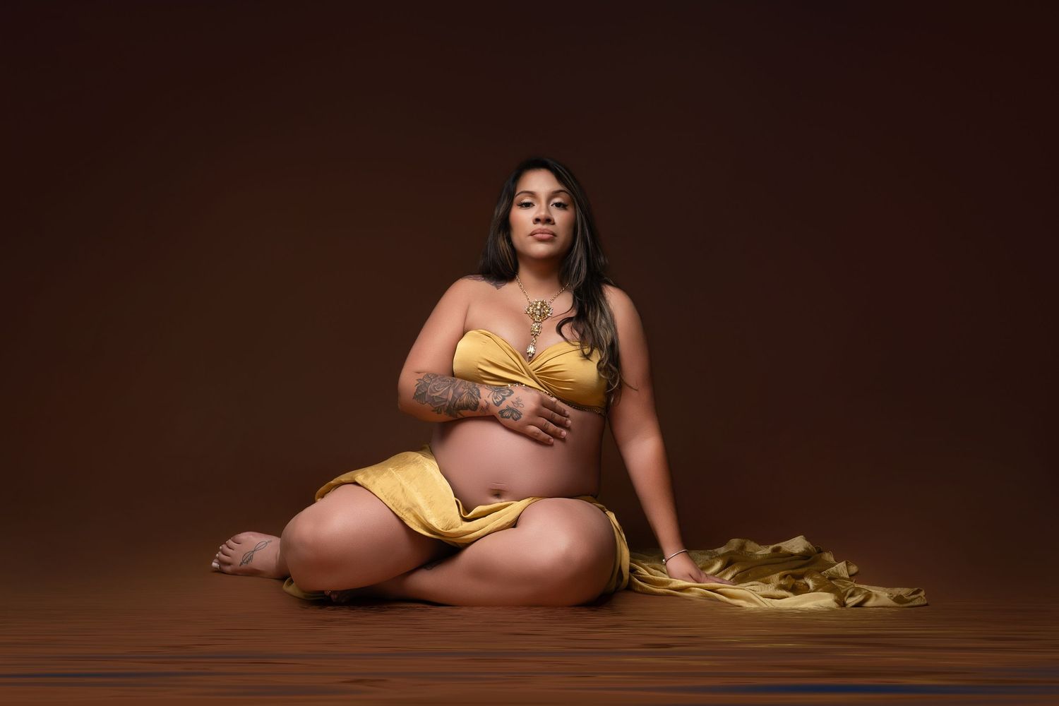 Artistic maternity photo series showing pregnant woman in yellow dress against dark brown background.