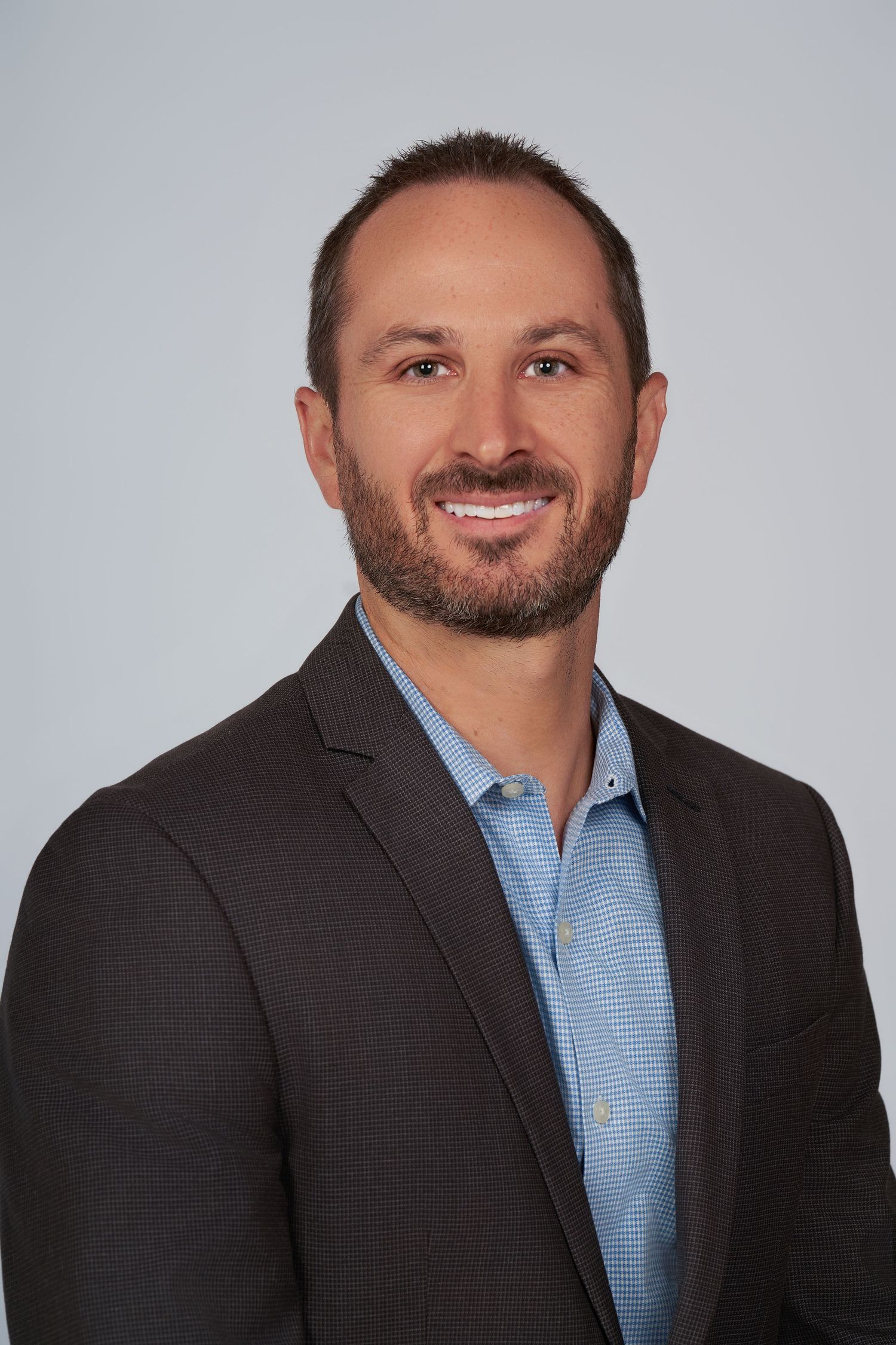 Business professional headshots featuring warm smiles and a blue collared shirt.