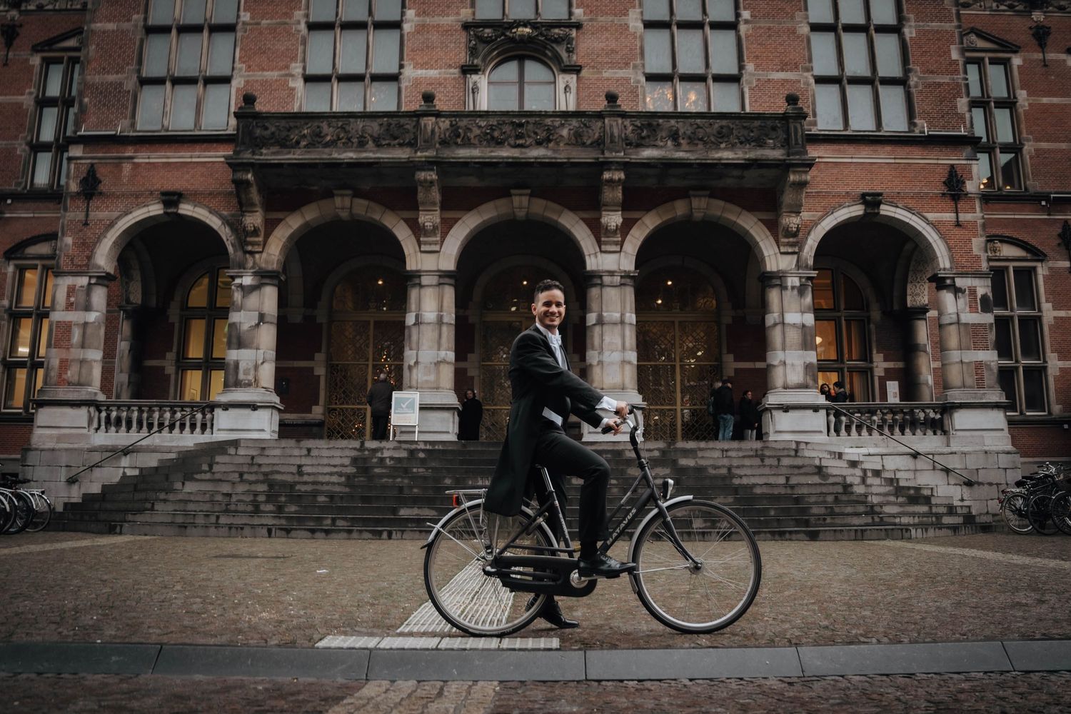 PhD candidate posing in front of the academiegebouw Groningen