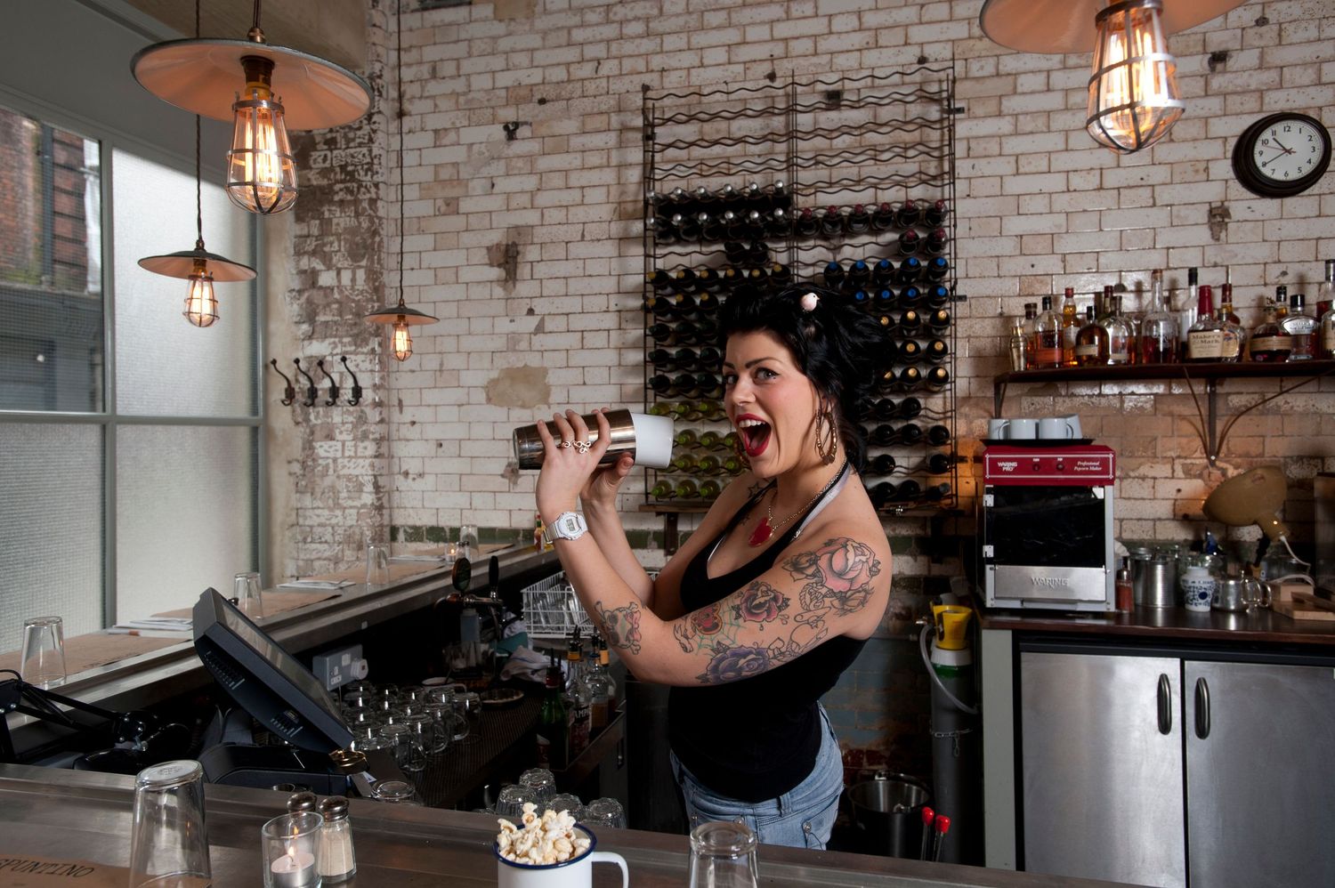 Spuntino. 61 Rupert Street, Soho, London W1D 7PW. Bartender Rachel shaking salt onto pop corn. 
Photograph by Danny Elwes