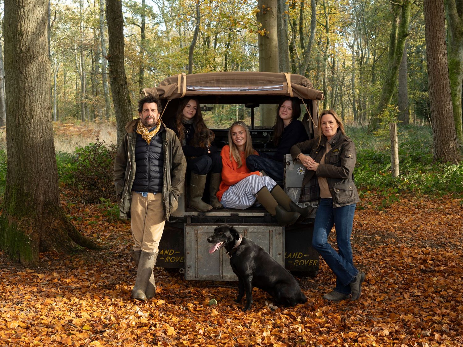 Sisters lounging in back of their old Land Rover vehicle with their Mum and Dad for family photograph for 'Before they Fly the Nest'