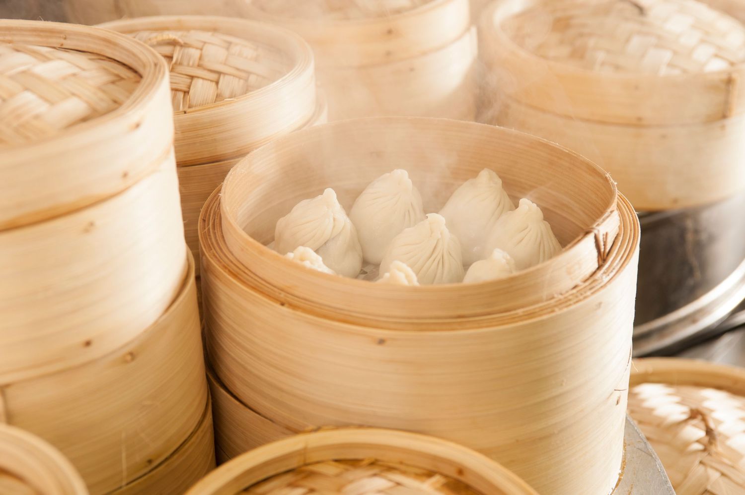 Steaming bamboo dim sum baskets filled with dumplings at a traditional Chinese restaurant.