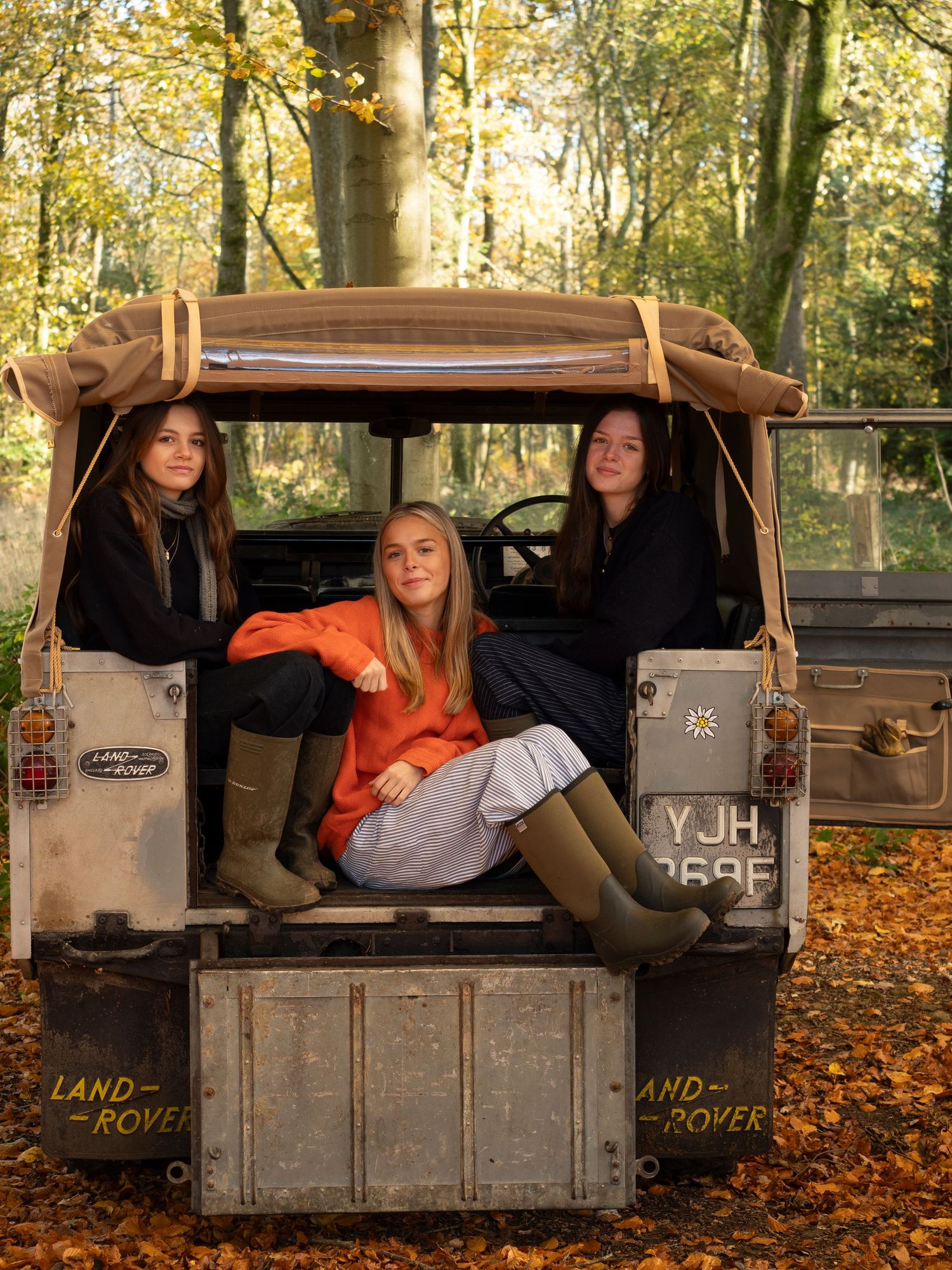 Sisters lounging in back of their old Land Rover vehicle  for family photograph for 'Before they Fly the Nest'
Photograph by Danny Elwes