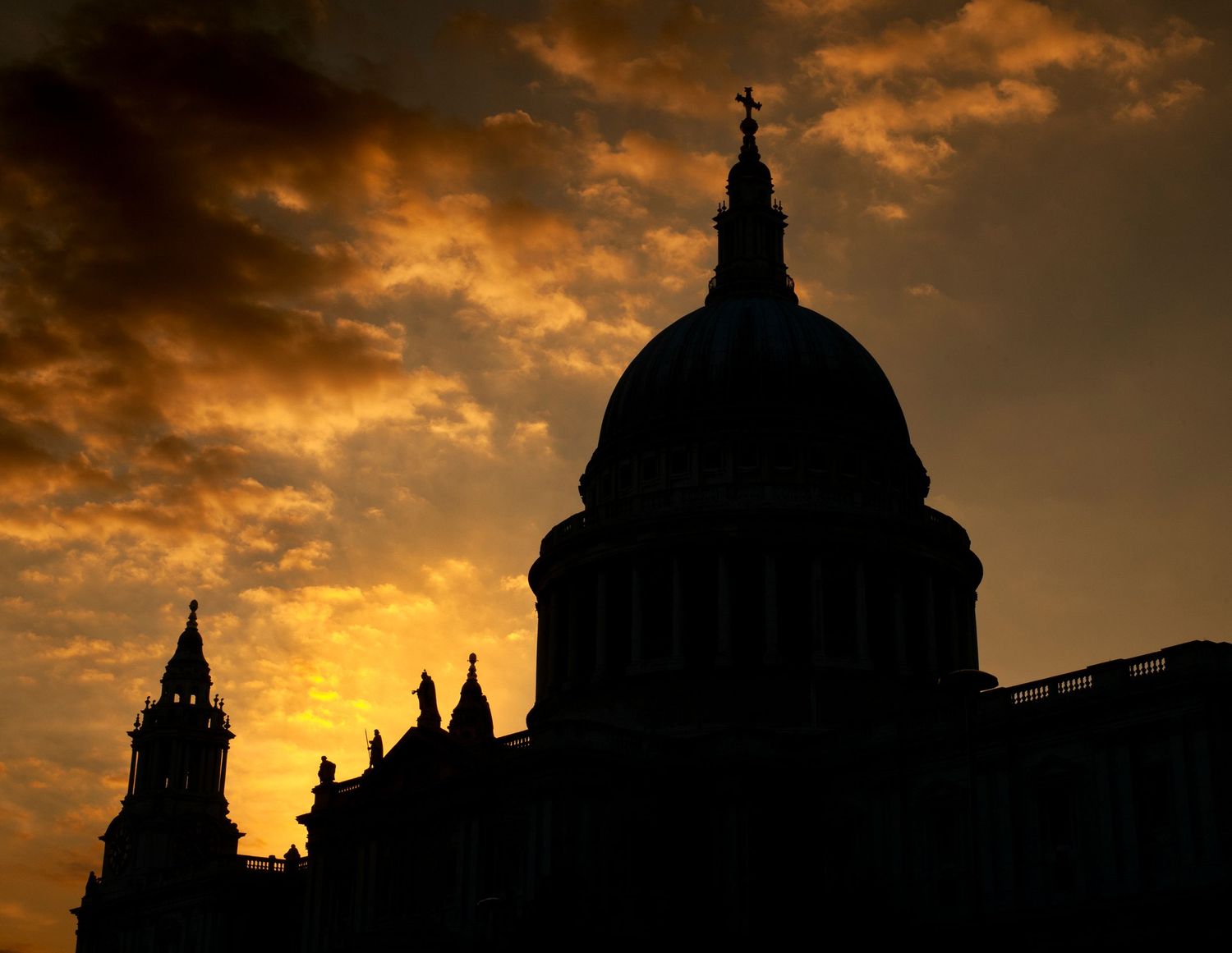 Dramatic sunset silhouette of St Paul's Cathedral dome against orange cloudy sky.
Photograph by Danny Elwes