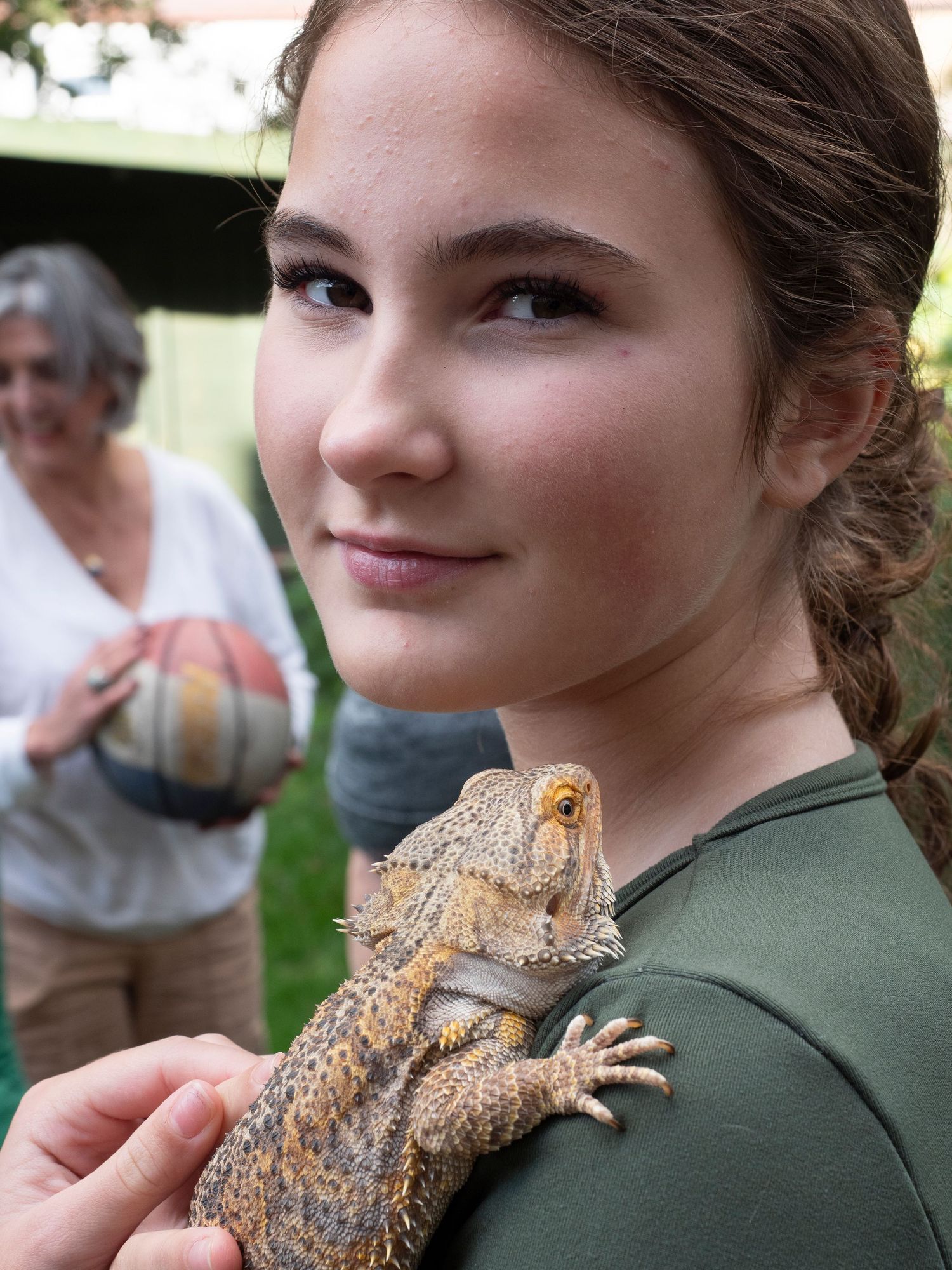Close-up of a bearded dragon lizard perched on girl for 'Before they Fly the Nest' family portrait, with family pets
Pic by Danny Elwes