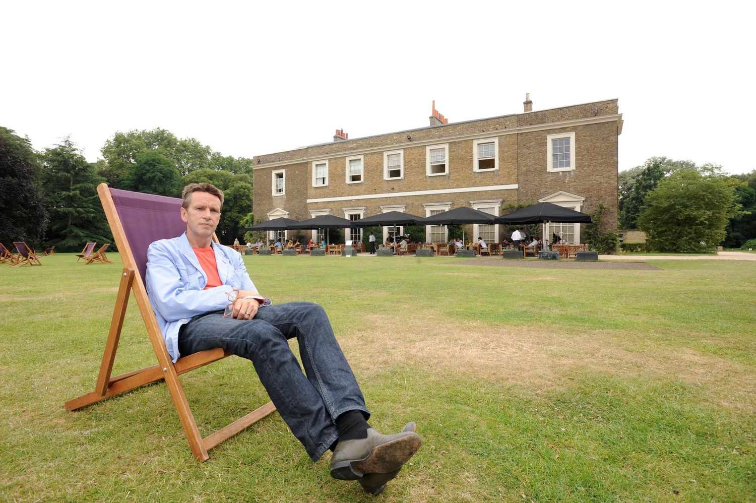 Oliver Peyton in a deck chair on the lawn in front of The Lawn, his restaurant & bar at The Fulham Bishops Palace
Photograph by Danny Elwes
