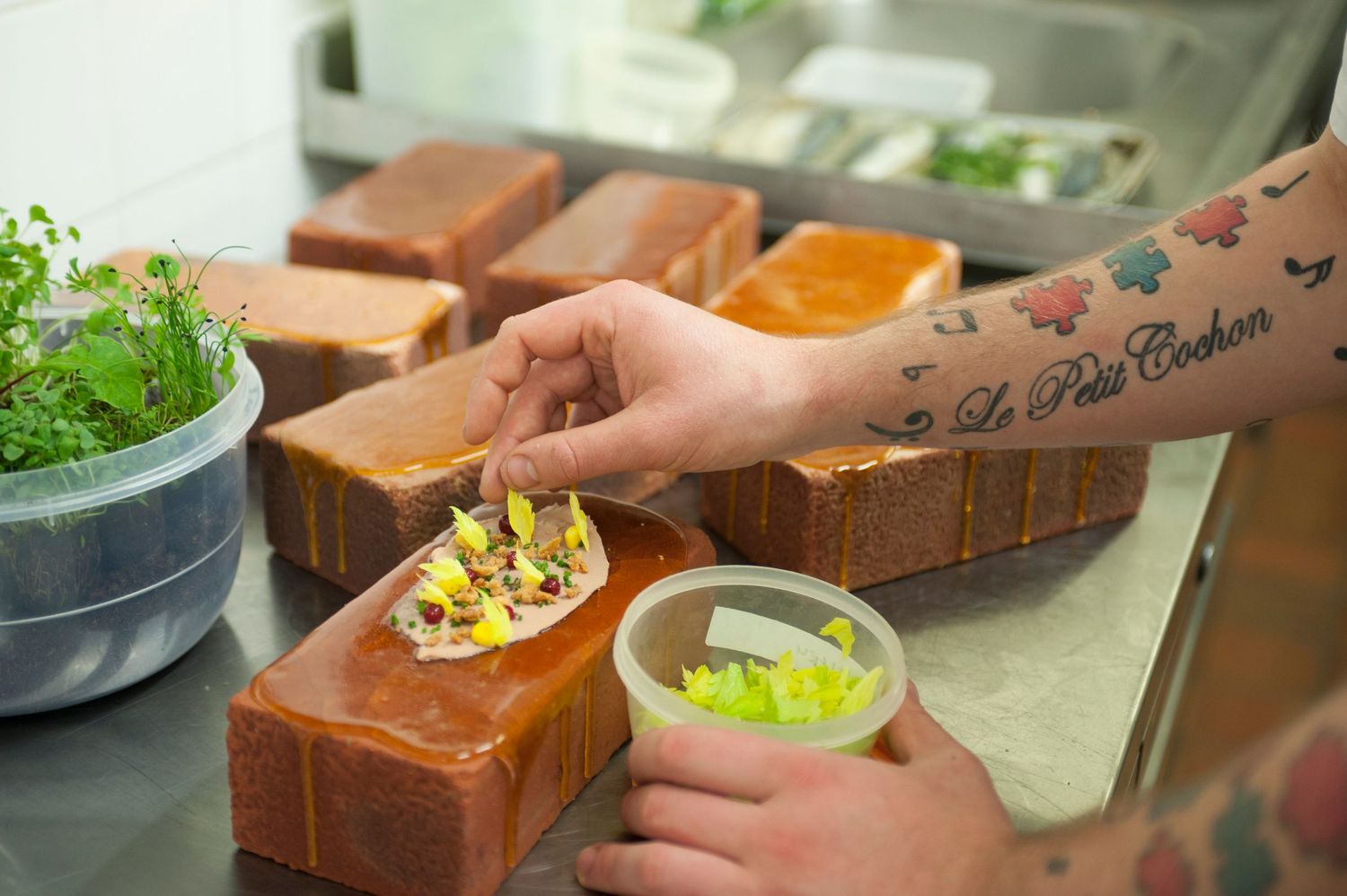 Chef assembling gourmet open-faced sandwiches on thick-sliced brioche bread with fresh toppings at Le Petit Cochon.
