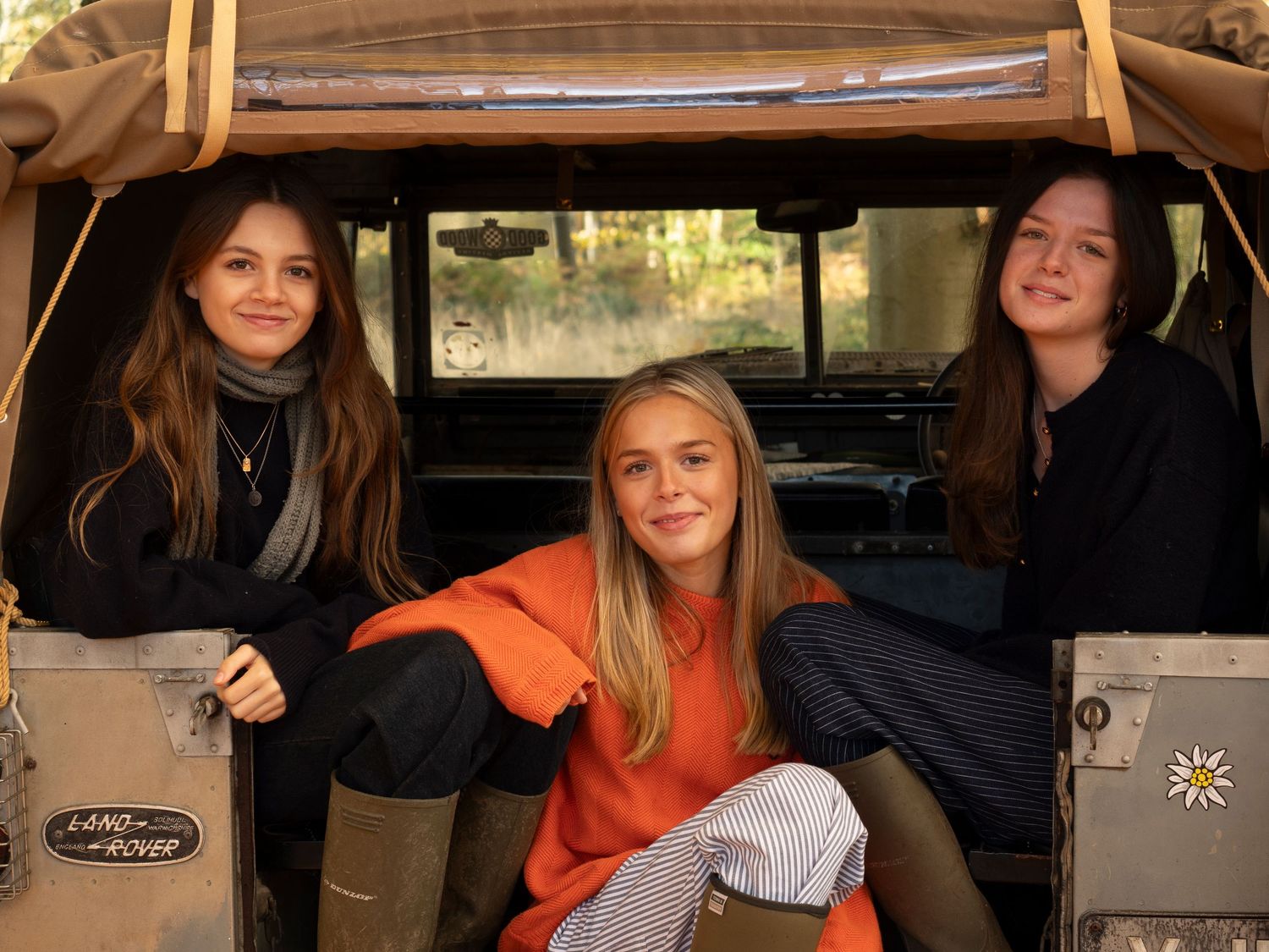 Sisters lounging in back of their old Land Rover vehicle  for family photograph for 'Before they Fly the Nest'
Photograph by Danny Elwes