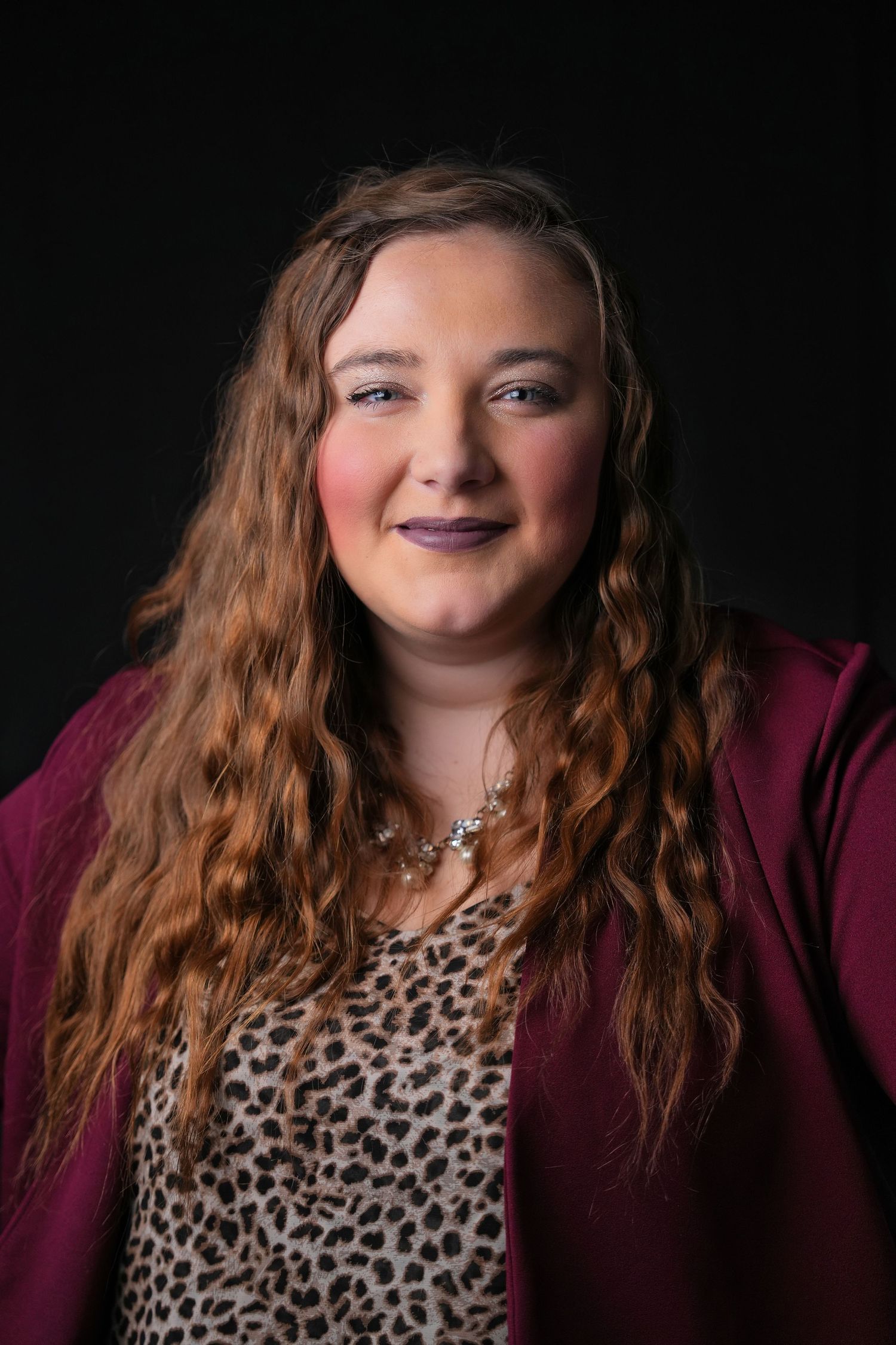 A series of headshots showing someone in a leopard print top and burgundy cardigan with long wavy hair.