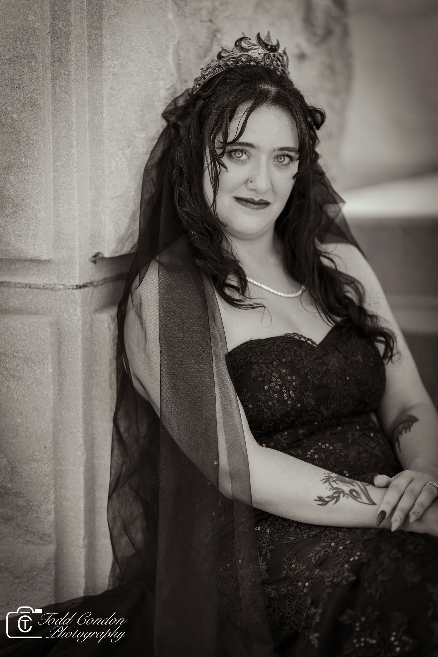 Artistic black and white portrait series showing dramatic poses against a stone column in a flowing dark dress.