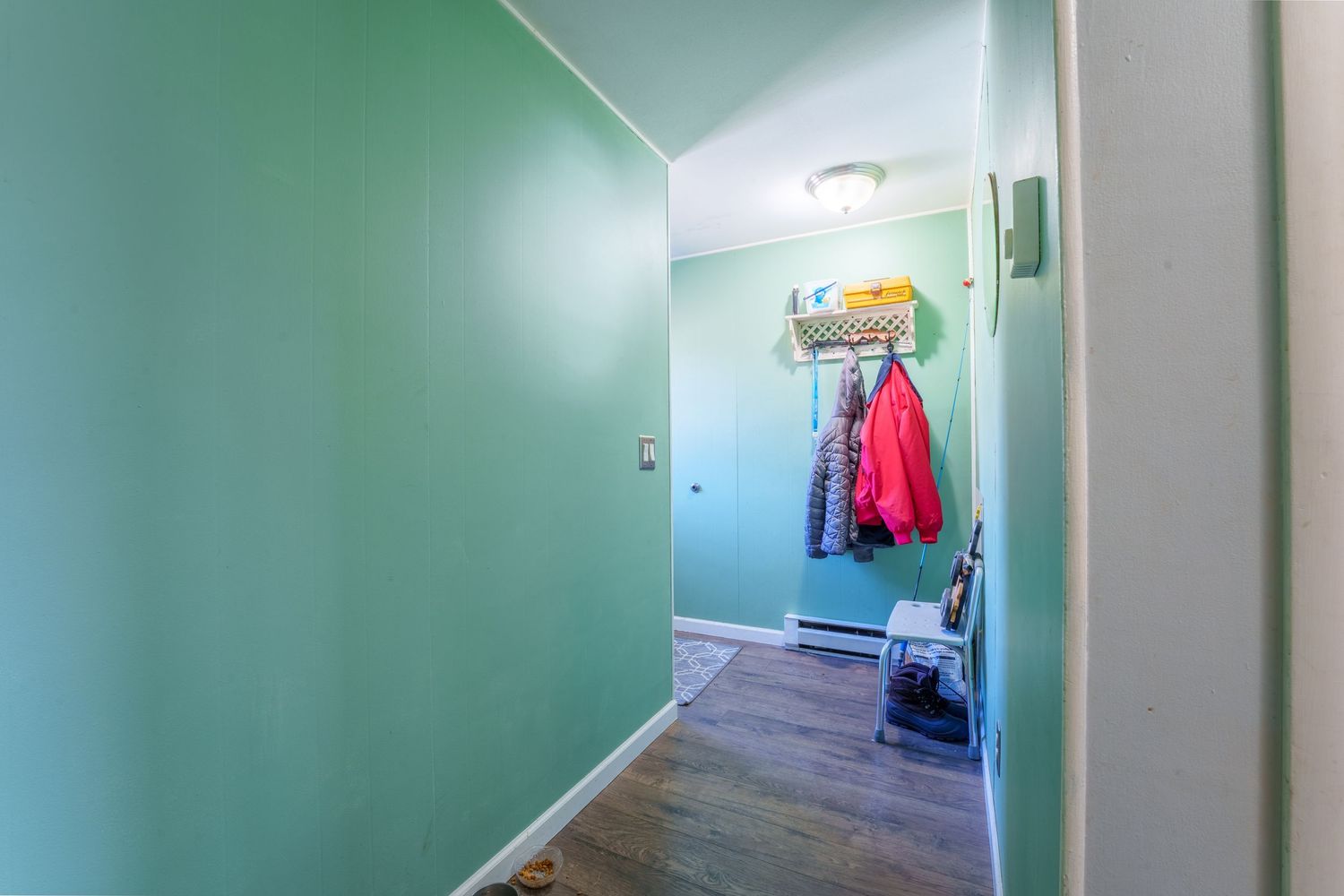 Long hallway with mint green walls and white trim showing multiple doorways.