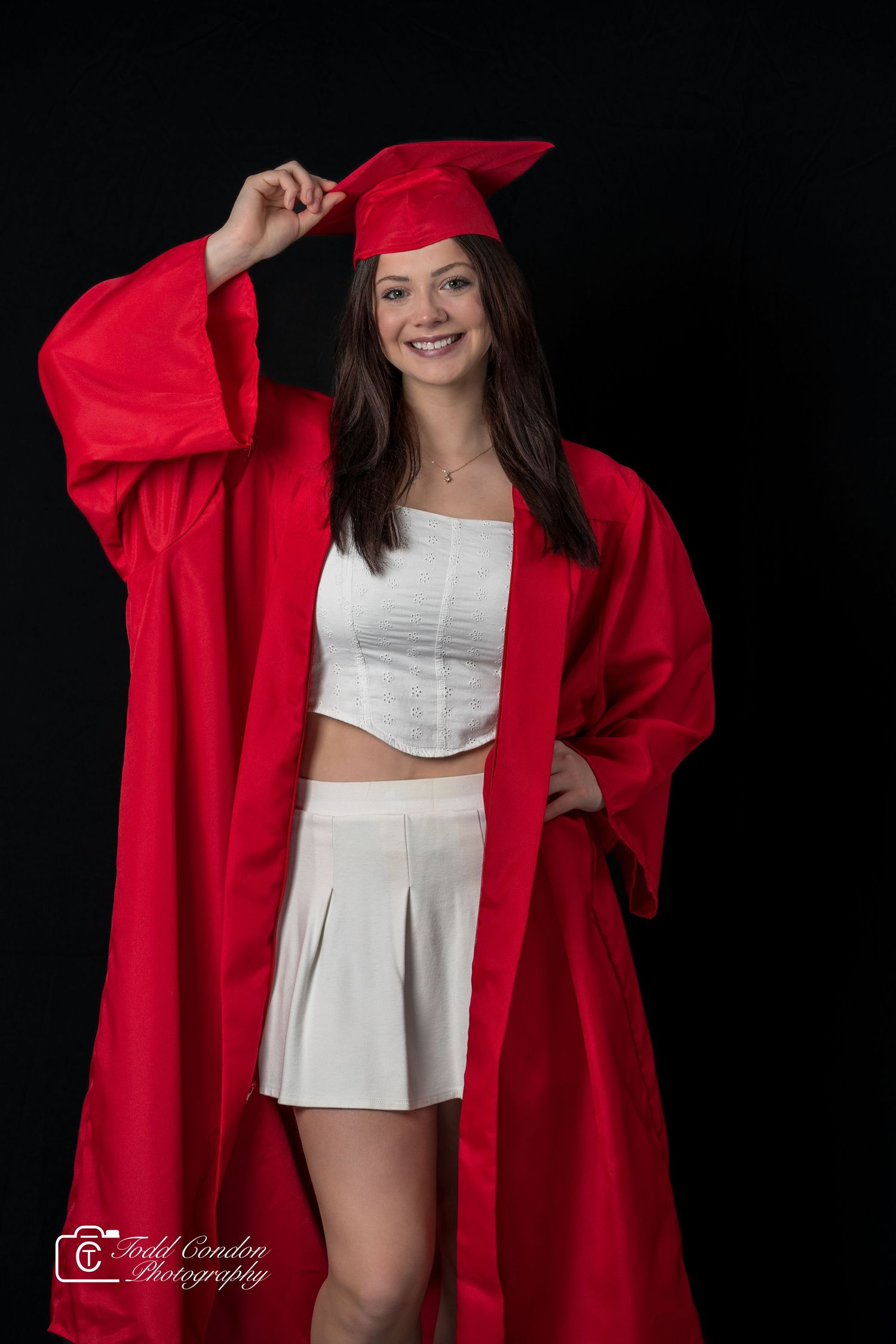 A figure in a flowing red cloak and white outfit poses dramatically against a black background in a photo series.