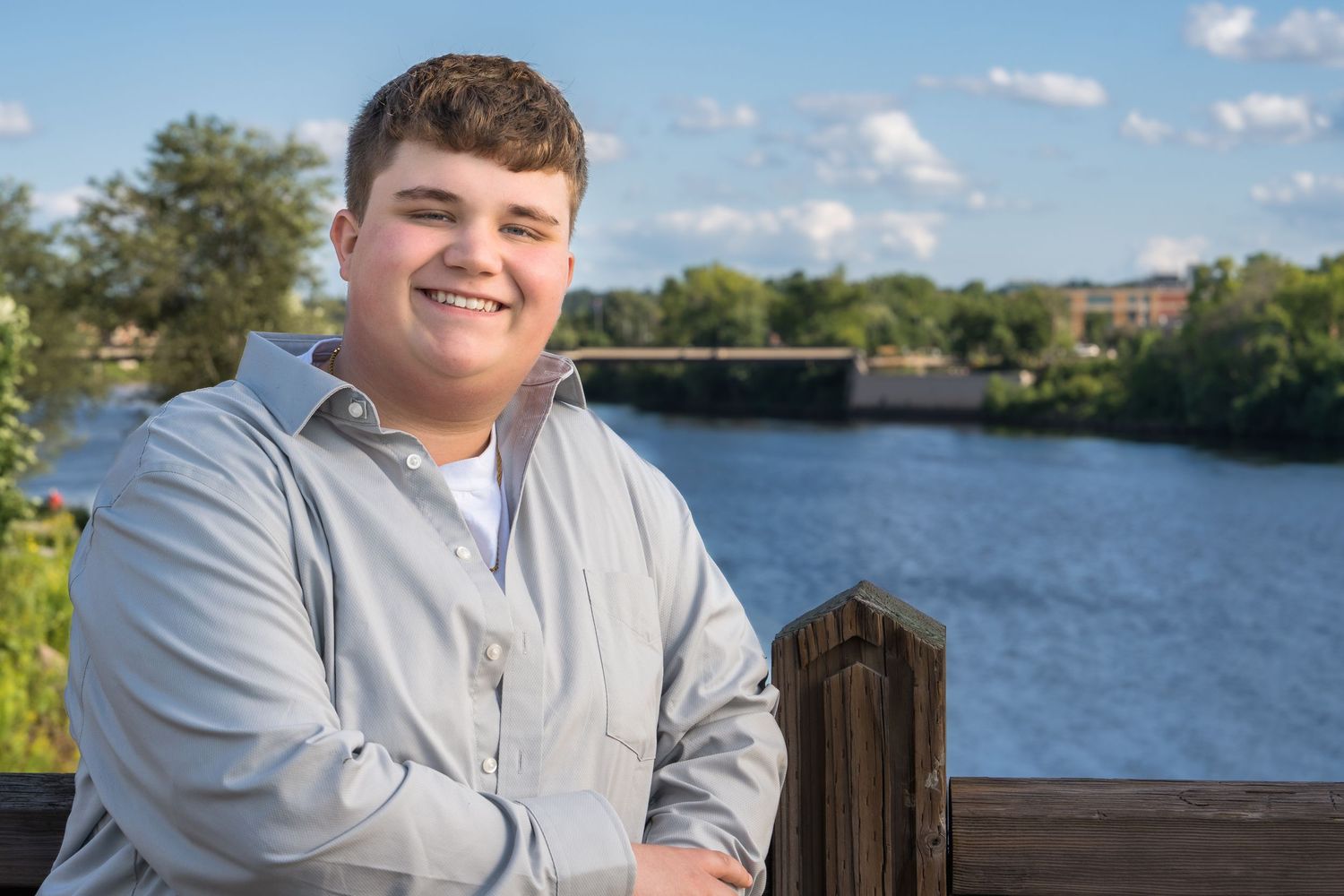 A series of senior portrait photos taken outdoors by a lake with wooden posts and natural scenery in the background.