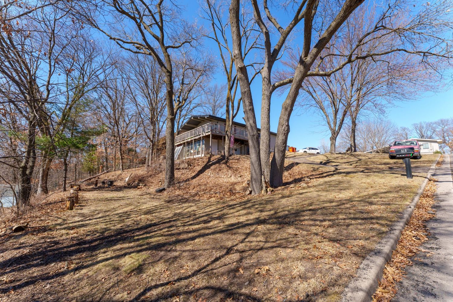 Multiple views of a wooded residential area with bare trees and sloping ground during winter season.