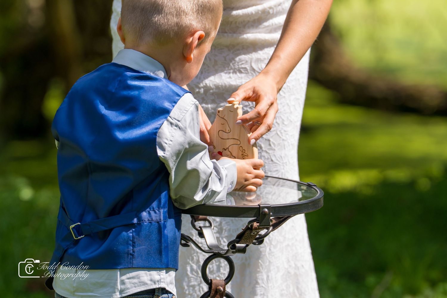 Close-up shot of hands holding each other against a sunlit garden background with soft bokeh effect.