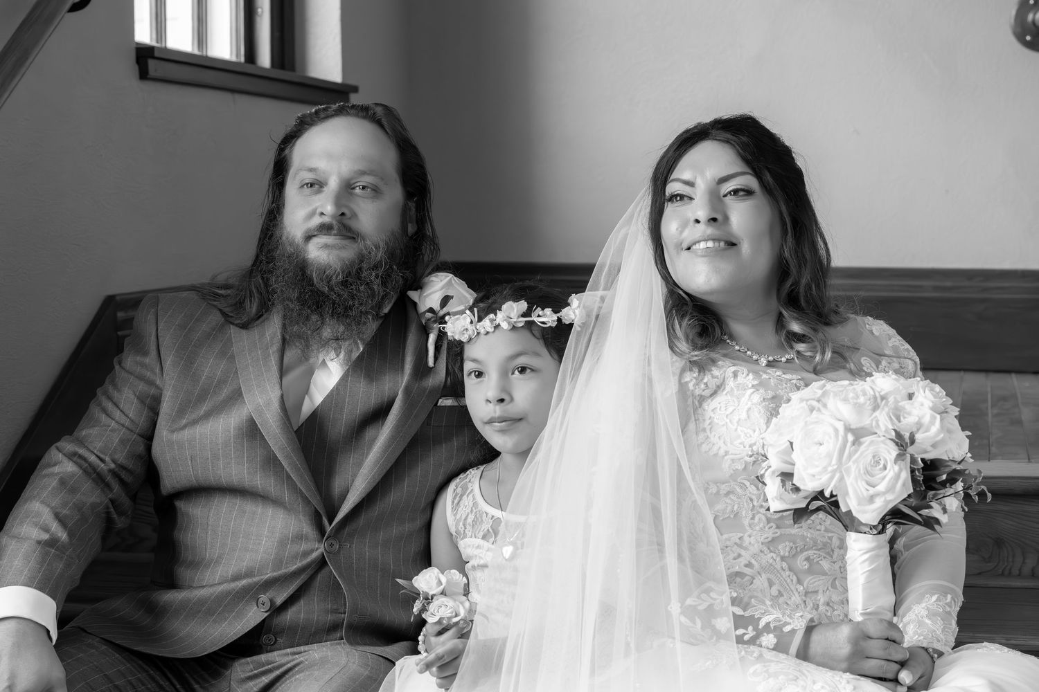 A black and white photo collage showing candid moments from a wedding celebration with guests and the happy couple.
