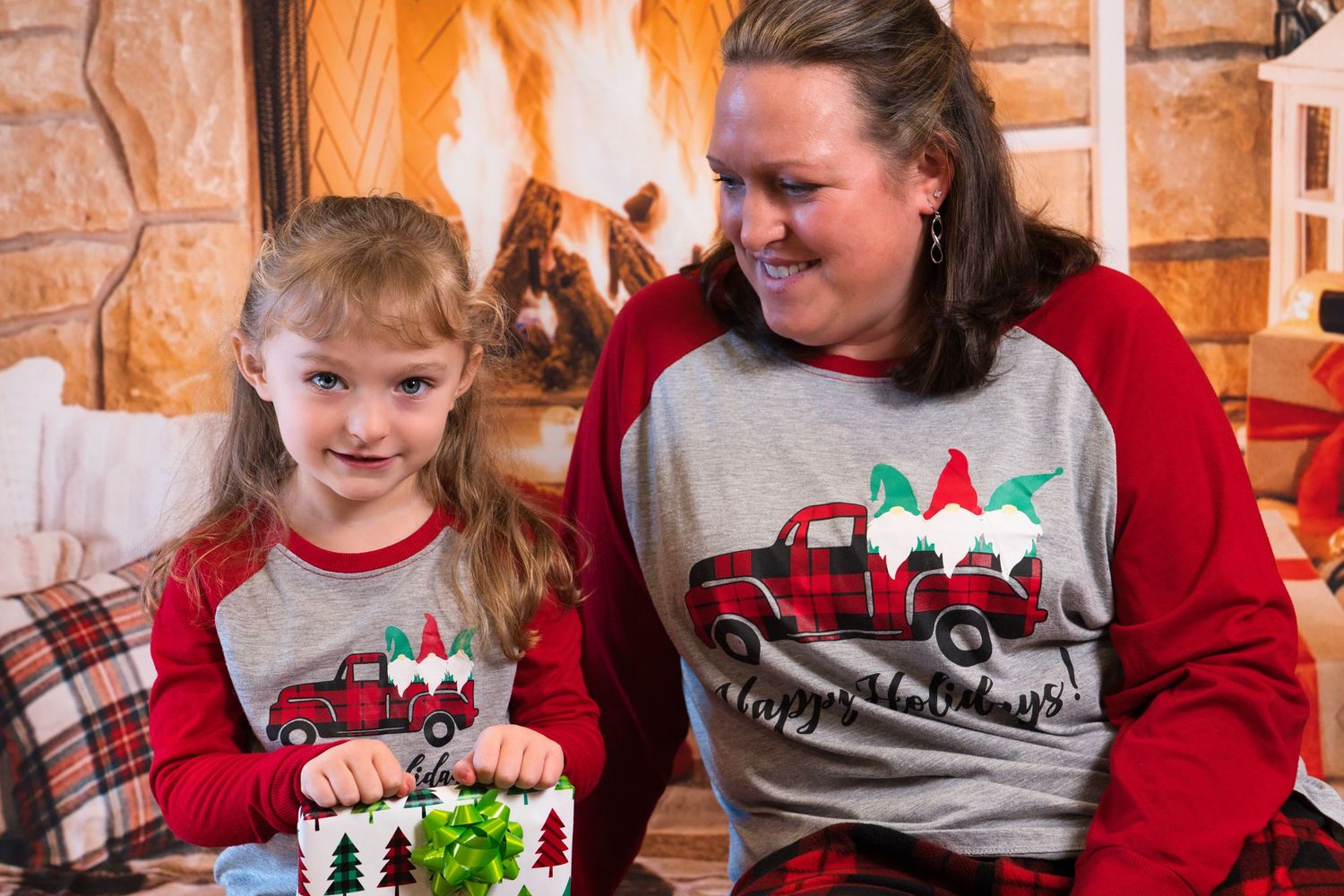 A group wearing matching holiday shirts and plaid pajamas gather together for a festive Christmas celebration.