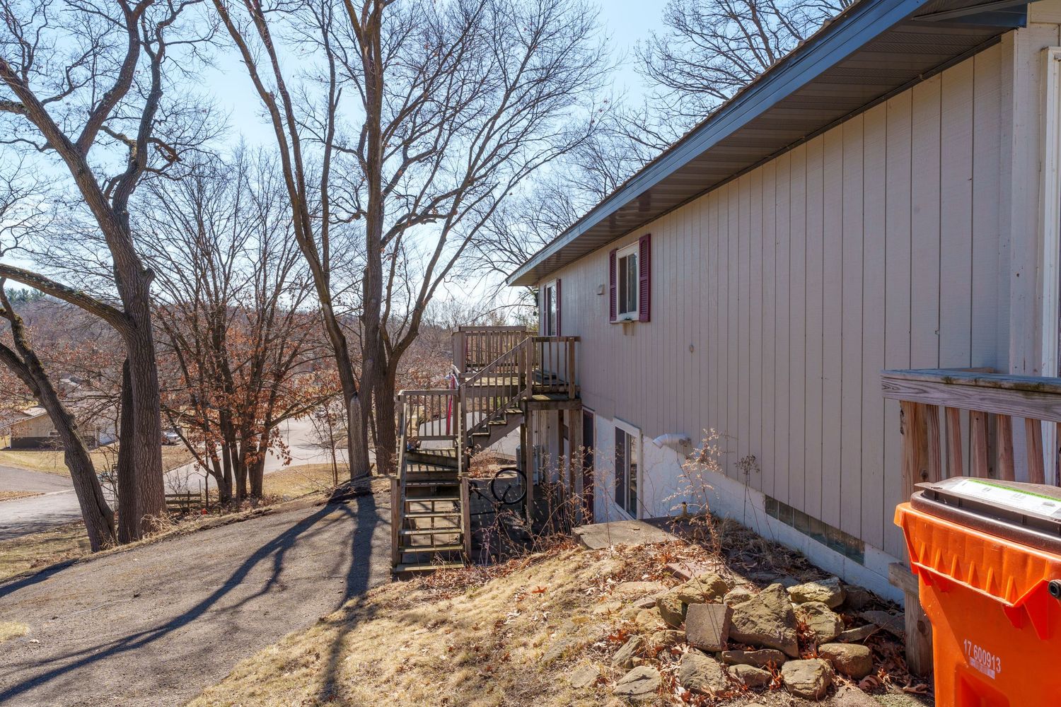 Multiple views of a residential backyard with trees, showing an orange dumpster and construction materials.