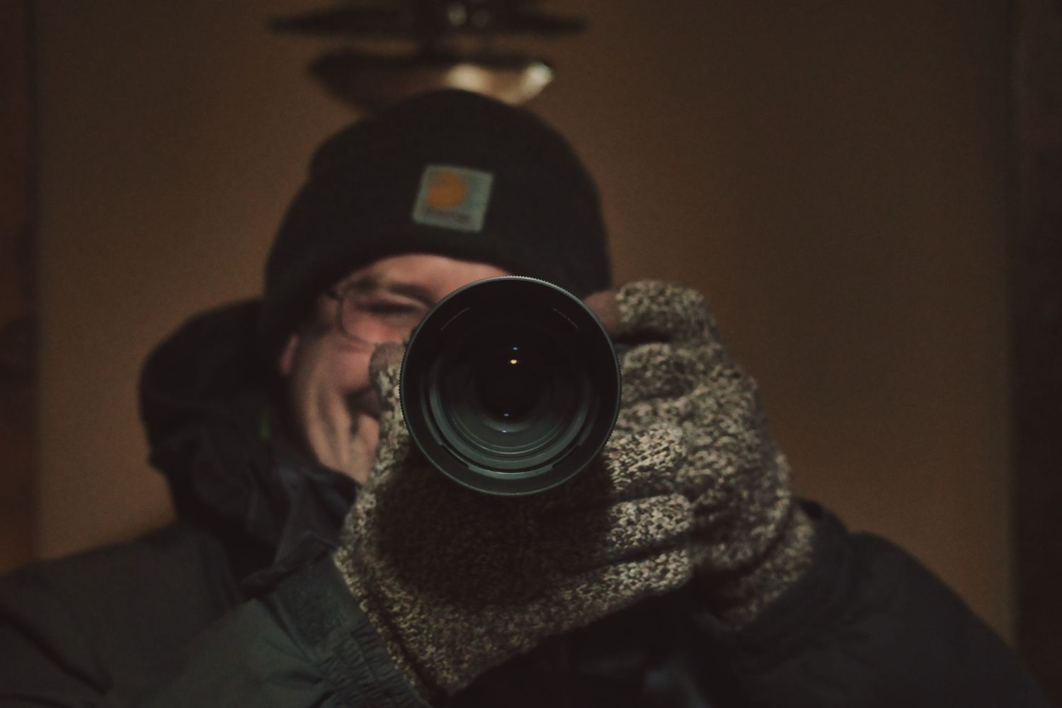 Dark moody photography portraits featuring camera equipment and winter gear.