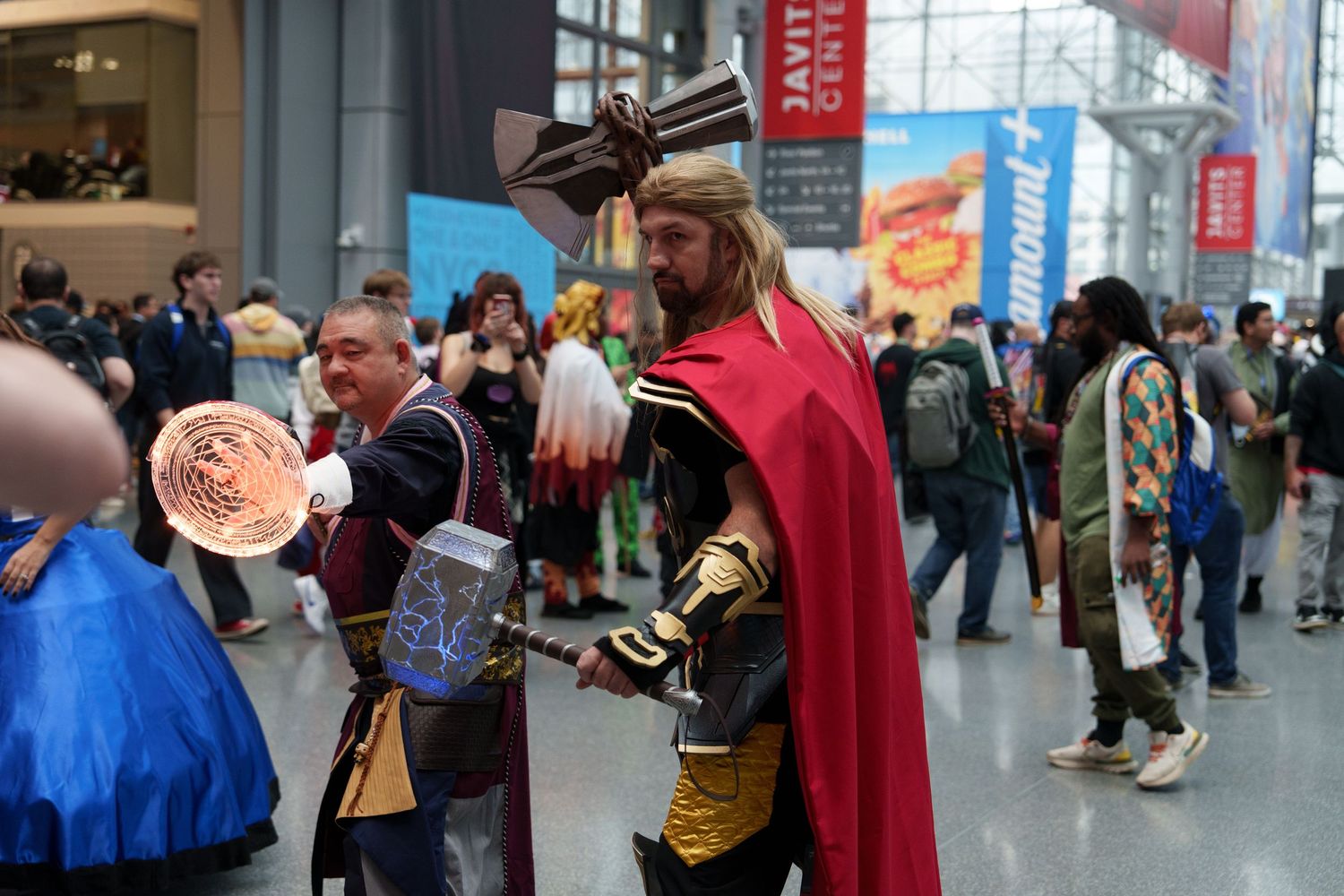 Cosplayers dressed as Thor and Doctor Strange pose at a comic convention inside the Javits Center.