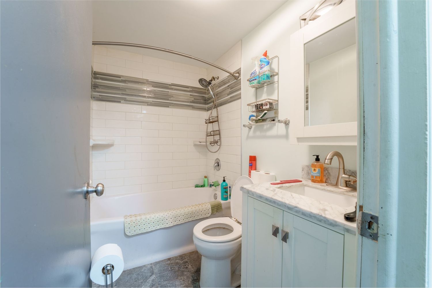 Small white bathroom interior with curved ceiling and basic fixtures.
