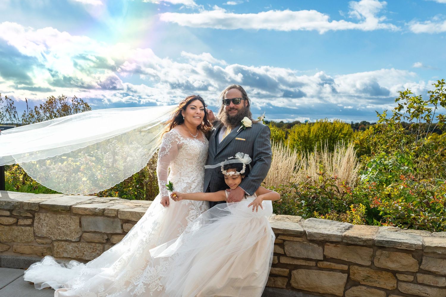 A couple shares a romantic moment against a scenic mountain backdrop during their outdoor wedding celebration.