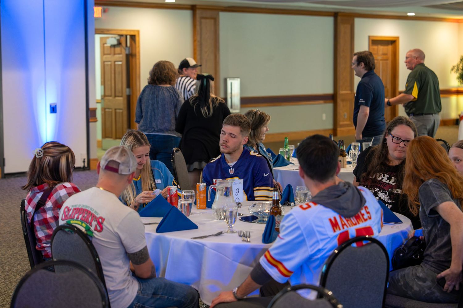 People gathered in a community room with blue lighting for a social event.