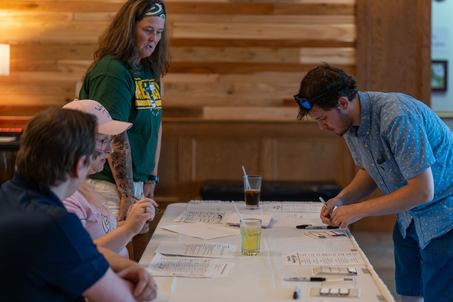 Students work together at wooden tables during an engaging study session in a rustic cabin-like setting.