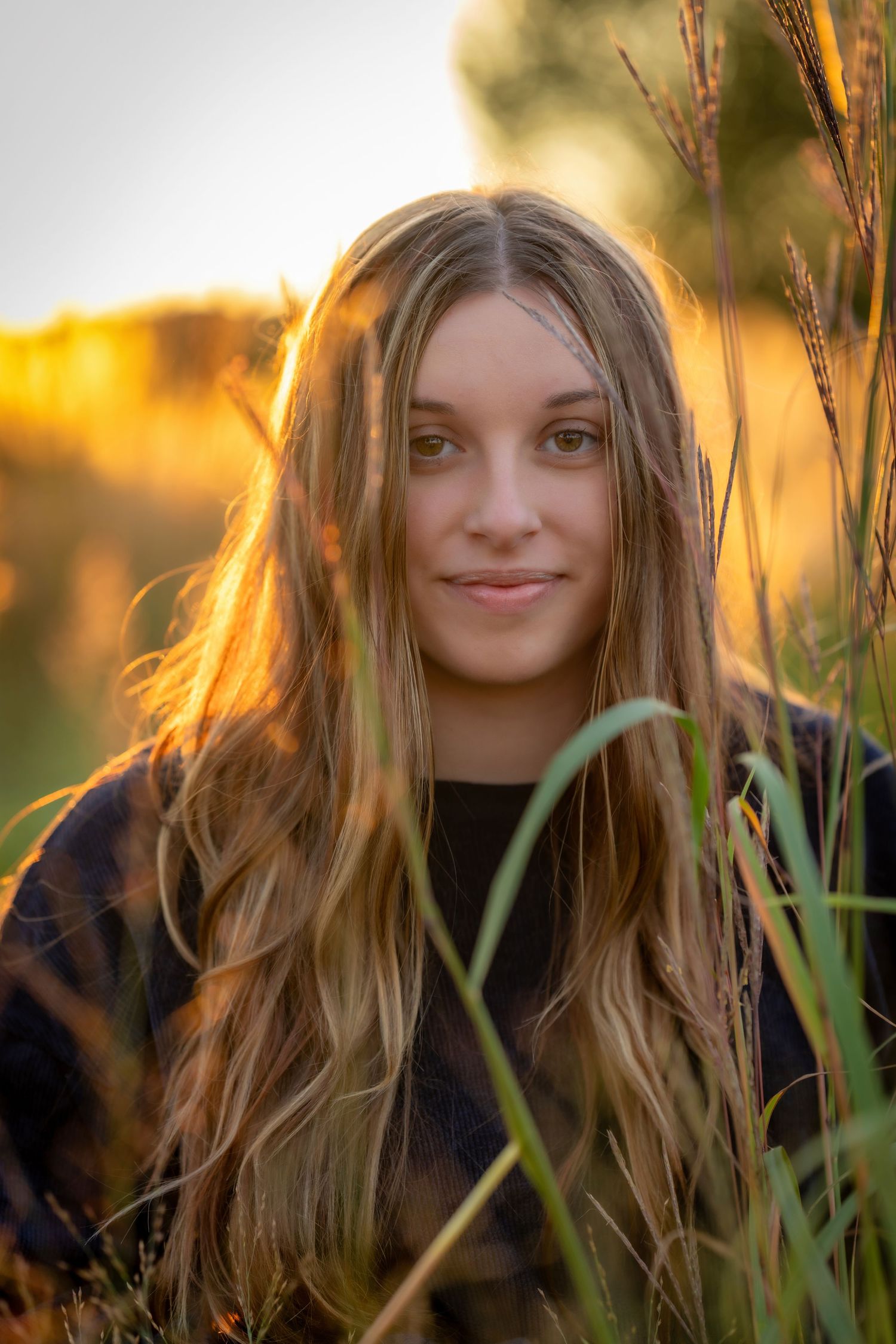 A series of portraits at sunset shows a person with long wavy hair among tall grass and warm golden light.