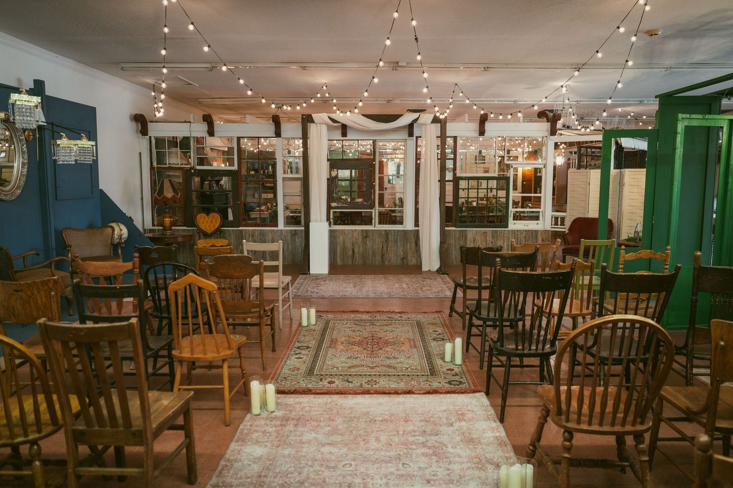 A dimly lit restaurant interior with wooden chairs and string lights creating a cozy, rustic atmosphere.