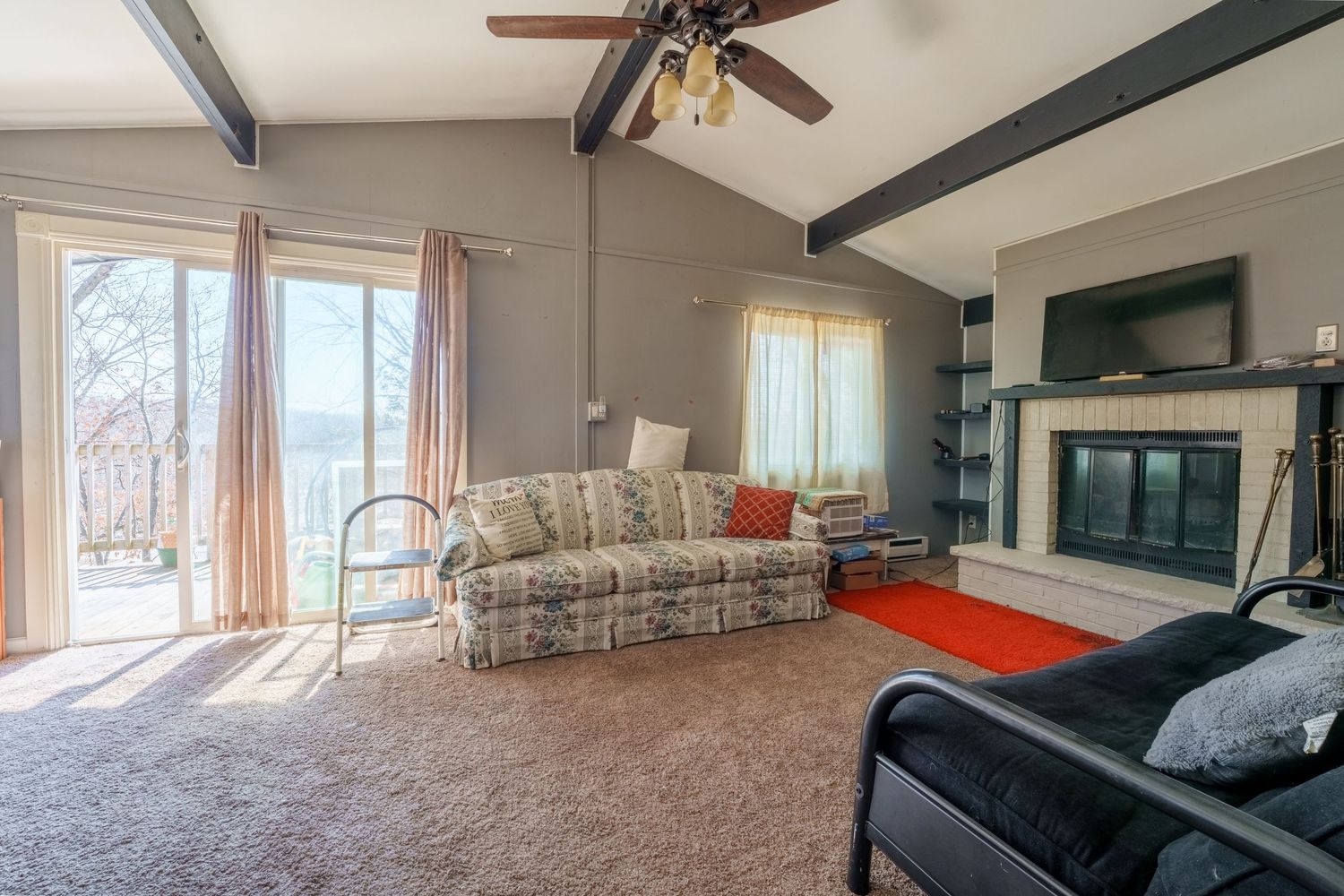 Wide angle view of an open concept living space with hardwood floors and large windows.