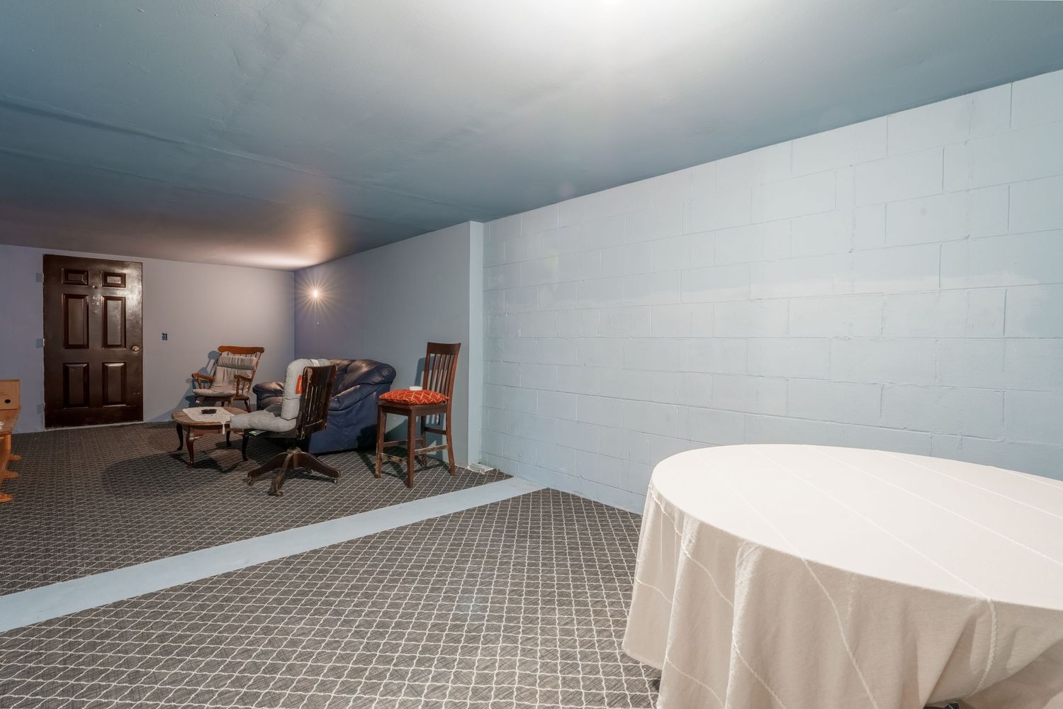 Panoramic view of an open basement area with gray carpet and white walls showing multiple angles of the space.