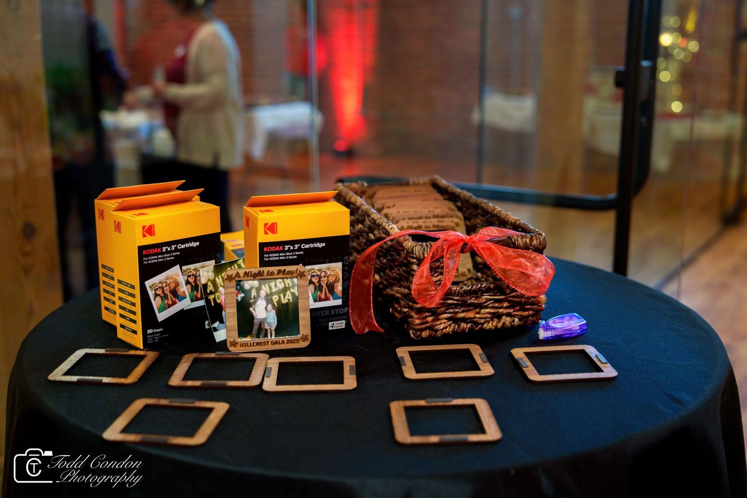 Kodak photo booth setup on black table with picture frames, film boxes, and decorative basket at an elegant event.