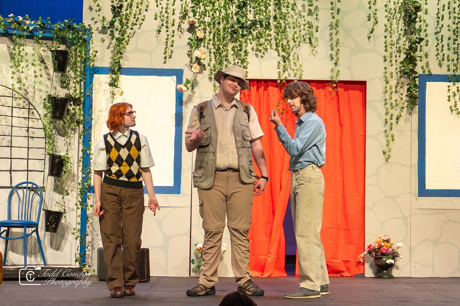 A stage performance scene showing actors in vintage costumes performing in what appears to be a theatrical production.