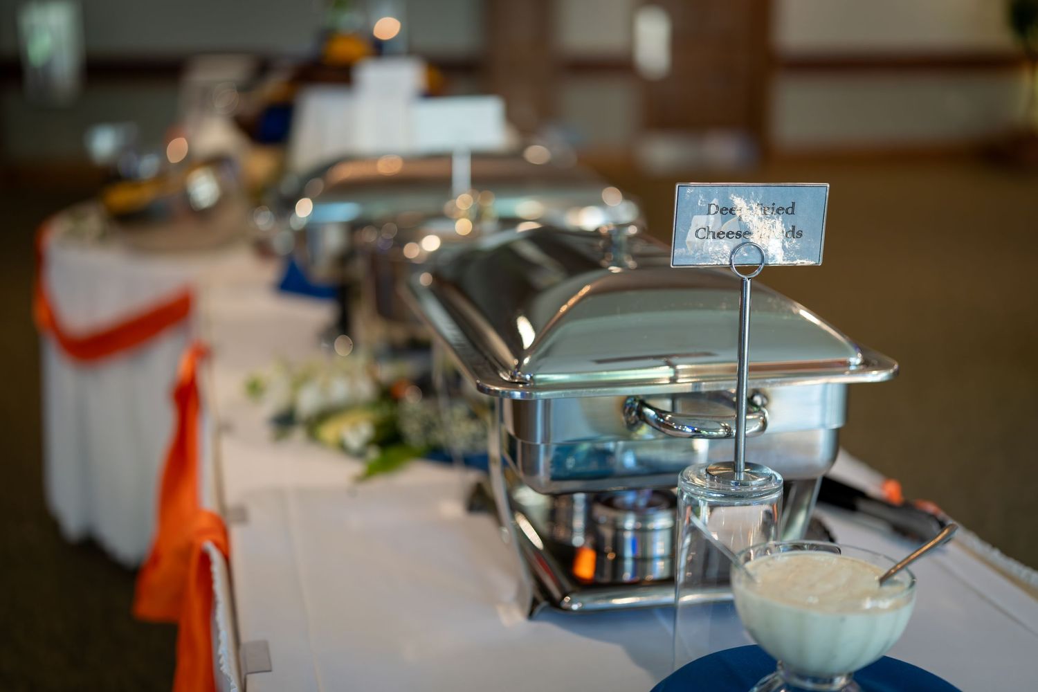 Stainless steel kitchen equipment and appliances arranged on a commercial countertop with white surfaces.