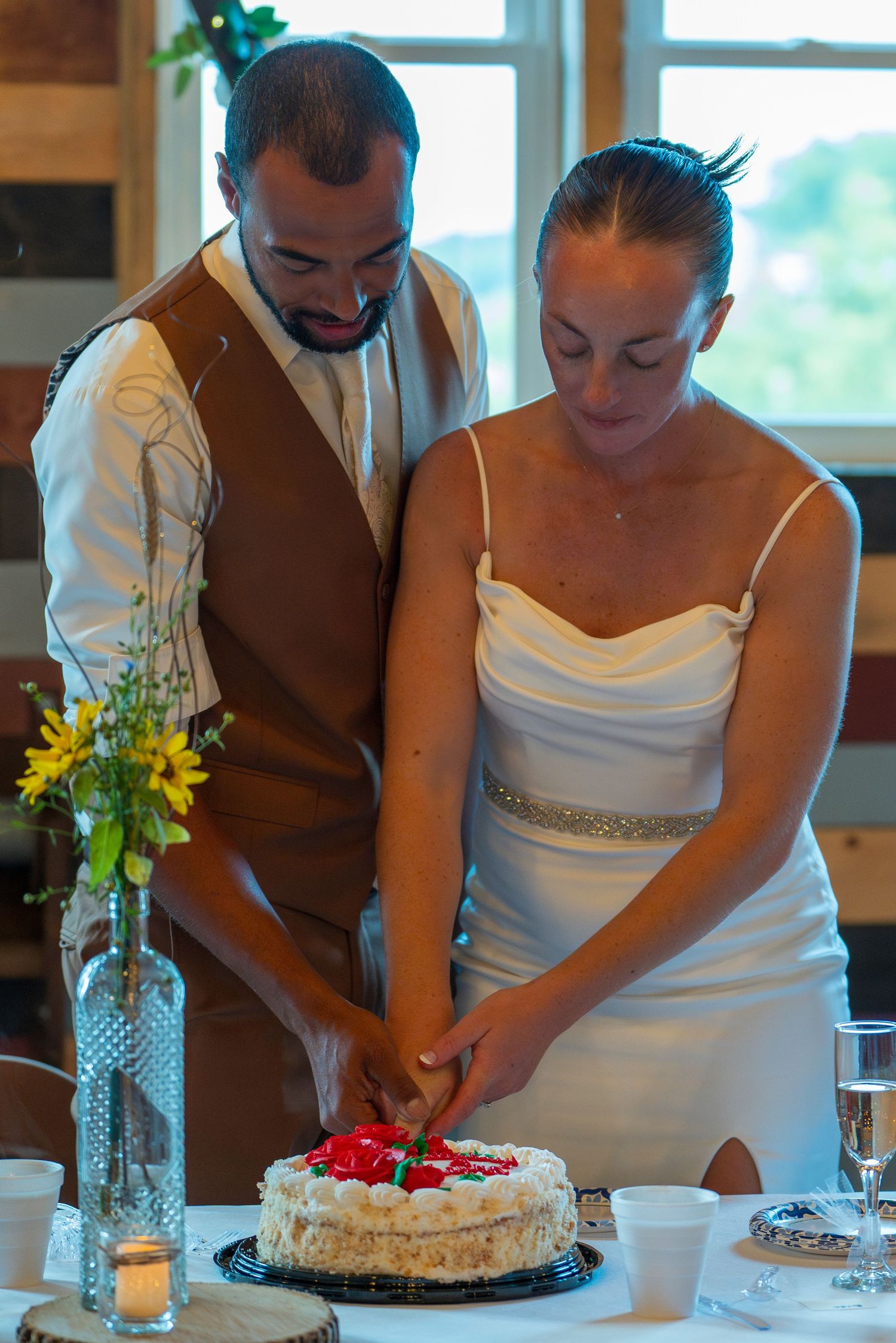 Newlyweds cut their wedding cake together in a series of progressive photos showing the traditional cake cutting moment.