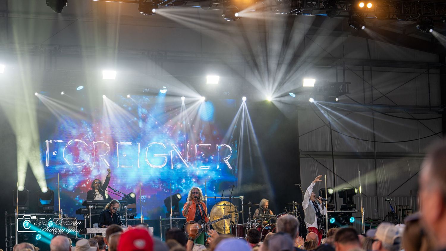 Concert stage illuminated with blue lights and fog effects showing performers silhouetted against dramatic lighting.